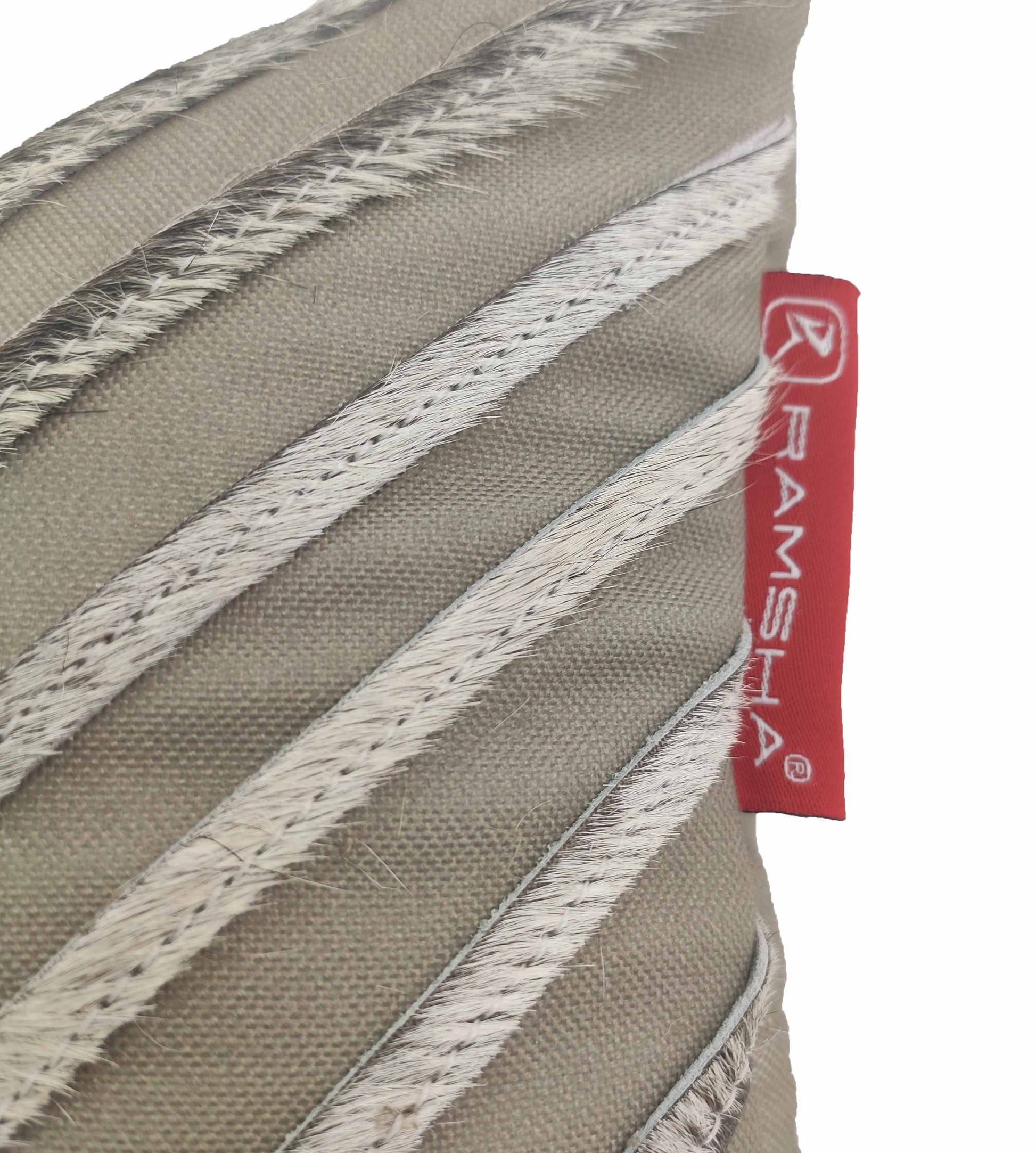 A close-up of the Leather And Polyester Cushion CS-109 by RAMSHA HOME, featuring durable beige diagonal woven lines and a red fabric tag on the side.