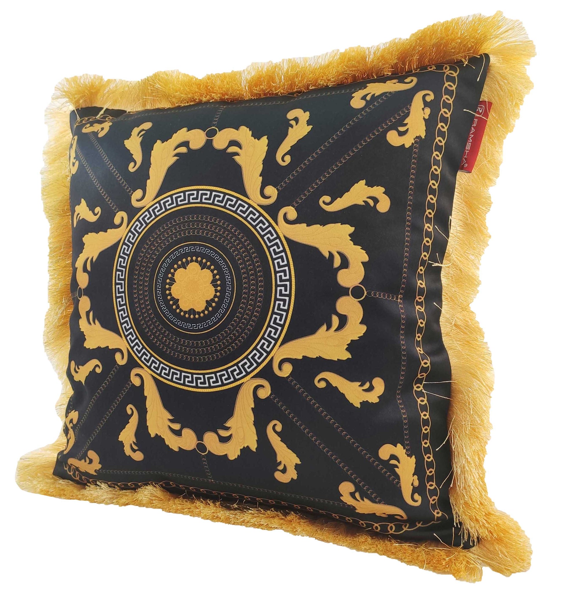 The RAMSHA HOME Polyester Cushion With Filler For Living Room CS-067 features black fabric with ornate gold baroque patterns, a central circular design, gold fringe trim, a red corner tag, and comes with filler for comfort.