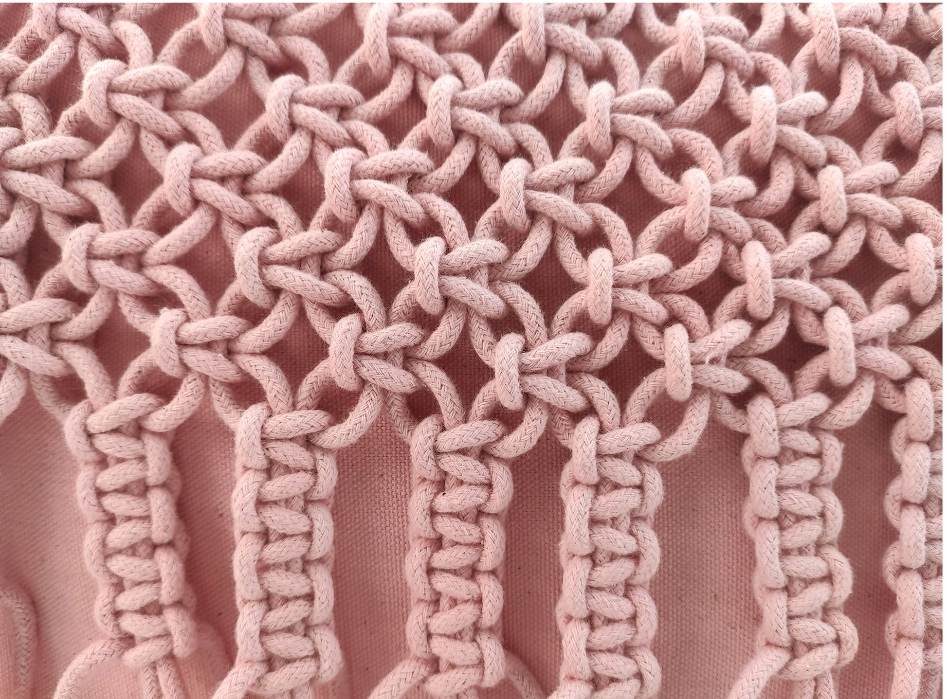 Close-up of detailed pink macramé knots in vertical and circular patterns on soft, thick cord—adding beautiful texture to the RAMSHA HOME Macrame Cotton Cushion With Filler, a stylish piece for home decor.