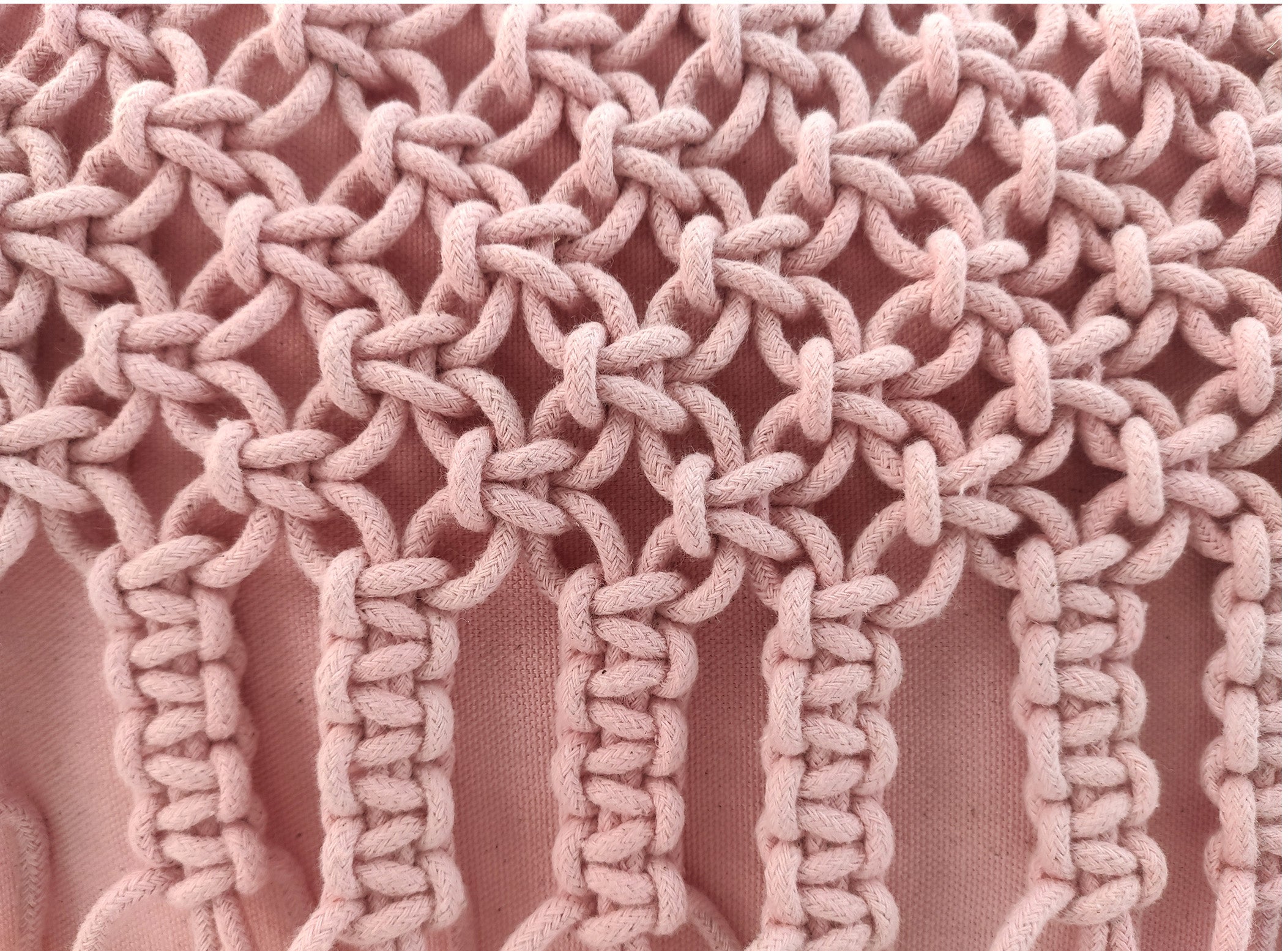 Close-up of detailed pink macramé knots in vertical and circular patterns on soft, thick cord—adding beautiful texture to the RAMSHA HOME Macrame Cotton Cushion With Filler, a stylish piece for home decor.