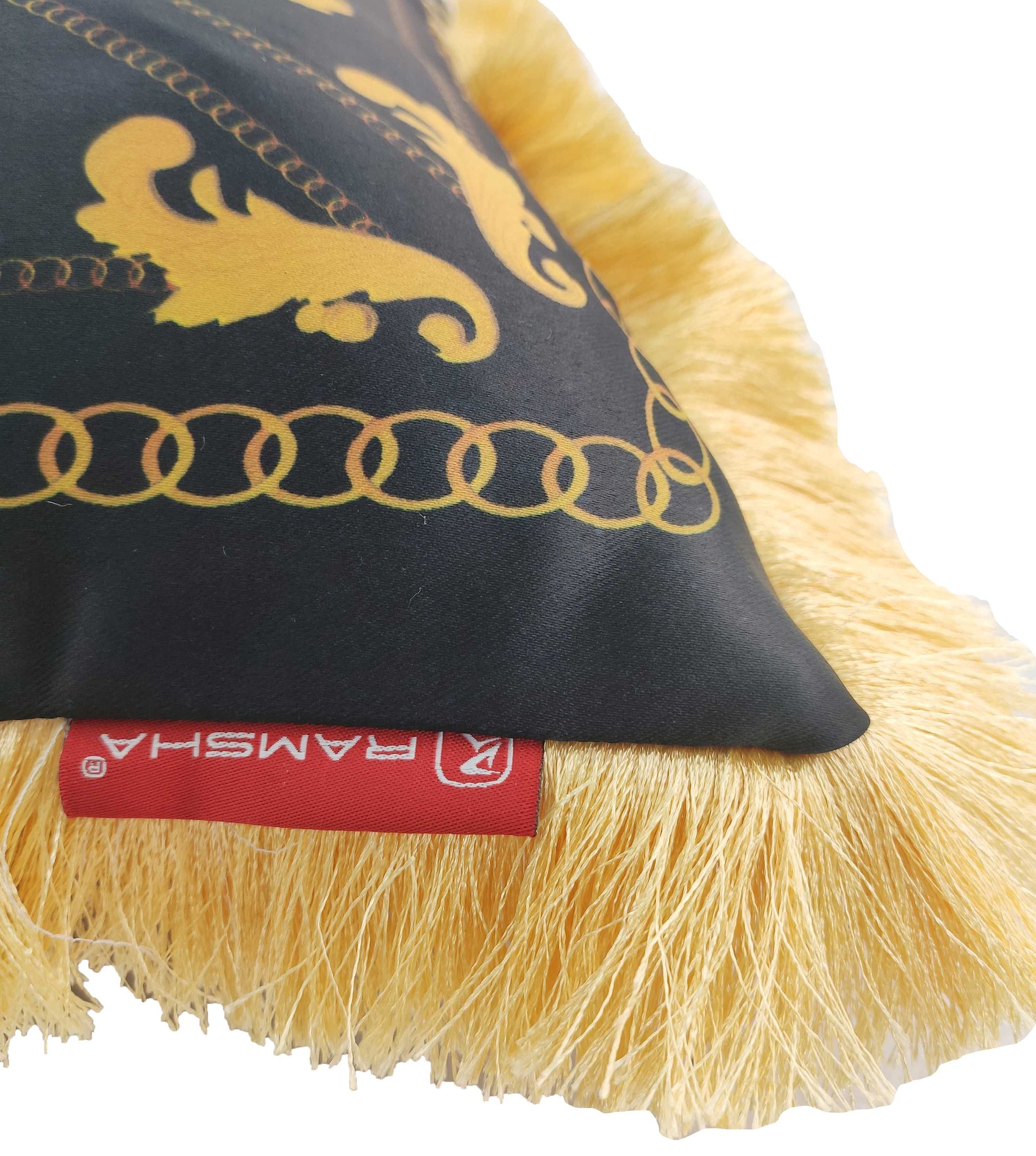 A close-up of the RAMSHA HOME Polyester Cushion With Filler For Living Room CS-067, showcasing its black and gold design with gold fringe trim and a red RAMSHA label. This stylish cushion includes a plush filler for extra comfort.