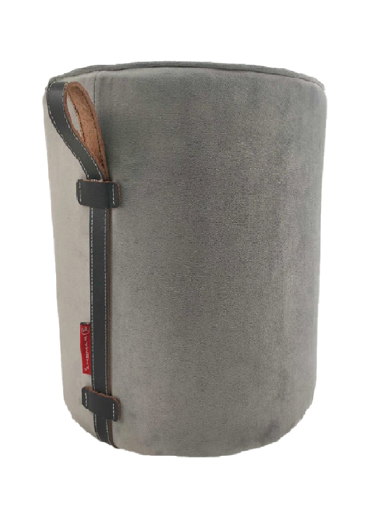 The RAMSHA HOME Leather Pedestal Pouf With Leather Handle is a round, gray ottoman with soft fabric, a black leather strap with brown accents, a red side tag, and a modern look against a plain white background.