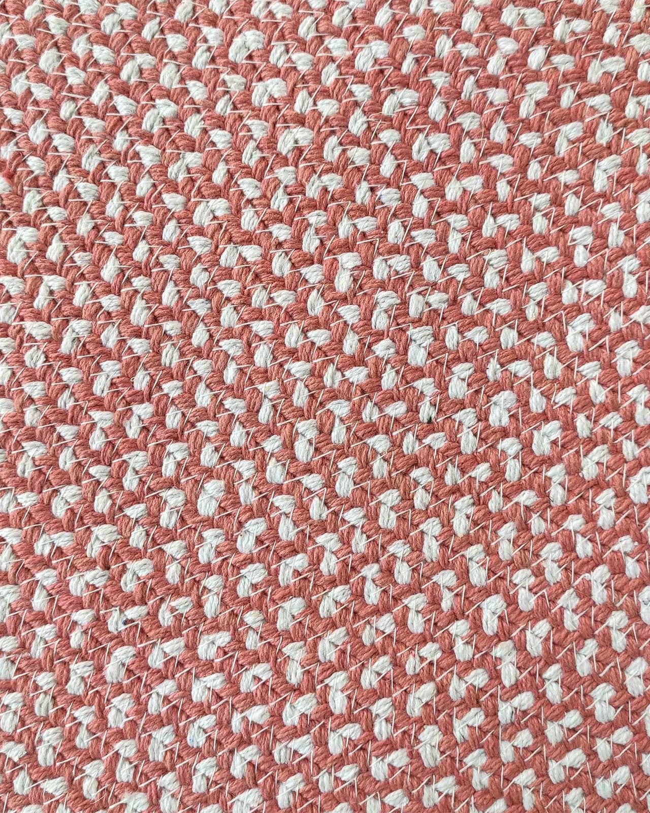 Close-up of the RAMSHA HOME Handmde Pink Color Round Rug BR 011, showing its pink and white woven textile in a checkerboard-like pattern, reminiscent of a textured braided rug.