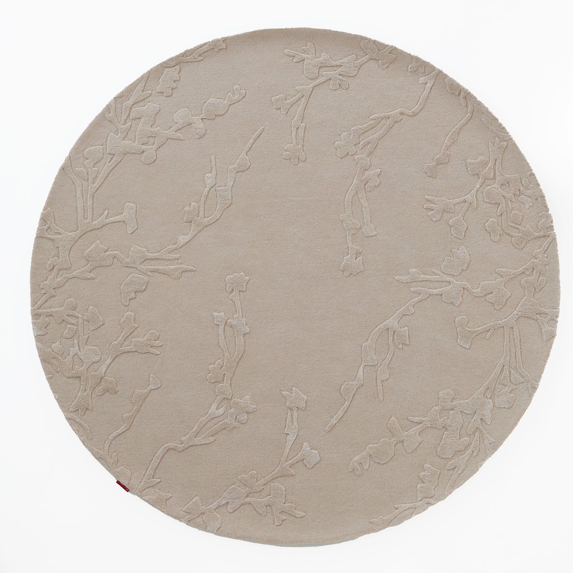 The RAMSHA HOME Handmade beige Color Decor Rug- HTWV 115 is a round, hand-tufted wool rug in beige with a subtle raised floral pattern, providing a neutral anchor against a white background.