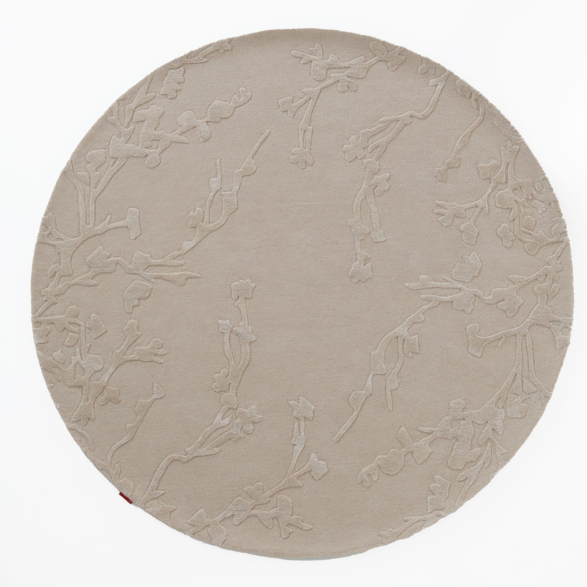 The RAMSHA HOME Handmade beige Color Decor Rug- HTWV 115 is a round, hand-tufted wool rug in beige with a subtle raised floral pattern, providing a neutral anchor against a white background.