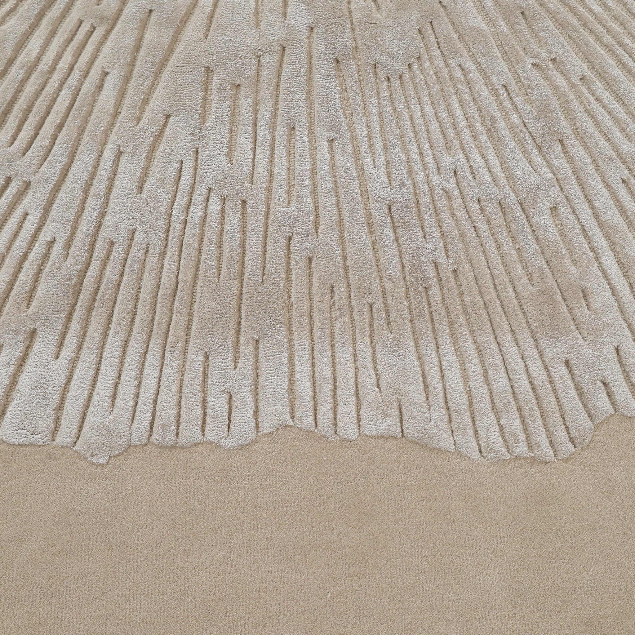 Close-up of the RAMSHA HOME Hand-Tufted Carpet For Home Decor HTWV-76, showcasing textured wool with raised, irregular linear patterns radiating from the top and a smooth, flat section at the bottom.