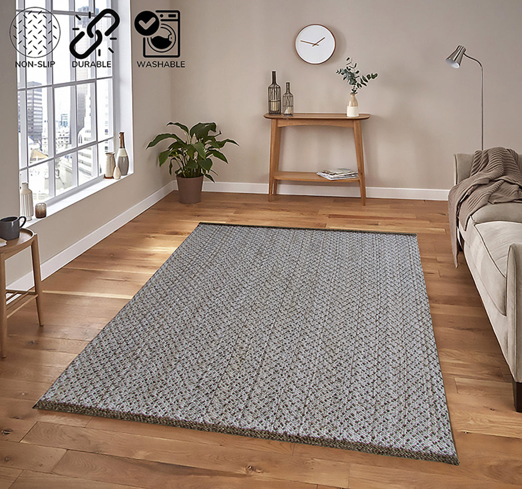 A modern living room with wood flooring features the RAMSHA HOME Handmade Natural & White Bedroom Crochet Rug (200x300cm), a sofa, side table with decor, plant, and large windows. Icons show the rug is non-slip, durable, and washable.
