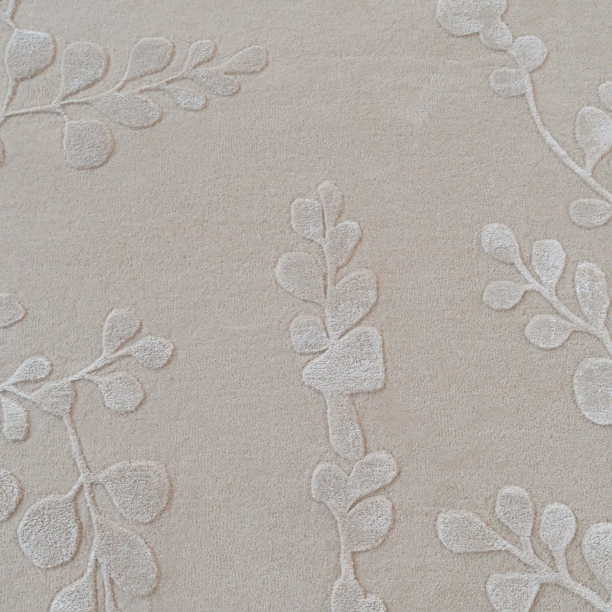 The RAMSHA HOME Artisan Handmade Decorative Area Rug – HTWV-116 features a beige, hand-tufted design with a raised textured pattern of abstract branches and leaves for an elegant botanical look.