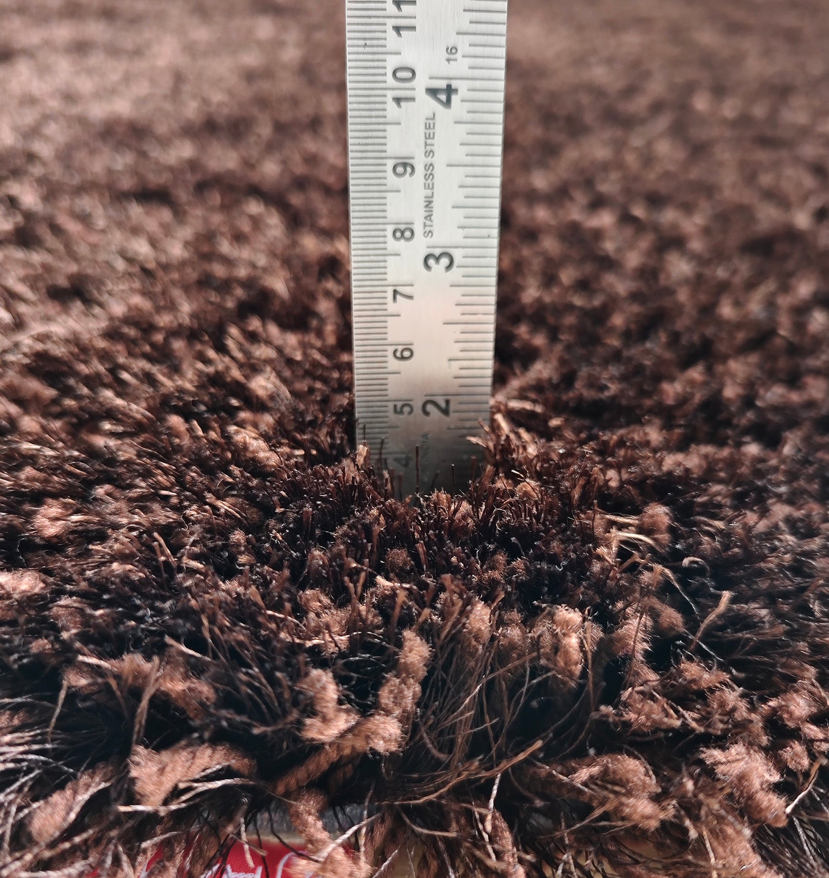 A close-up shows a ruler measuring the Fluffy Shaggy Round Shape Area Rug SG 04 - Brown by RAMSHA HOME, indicating a pile height of around 4 cm. The rug’s chocolate brown color and plush shaggy texture are clearly visible.