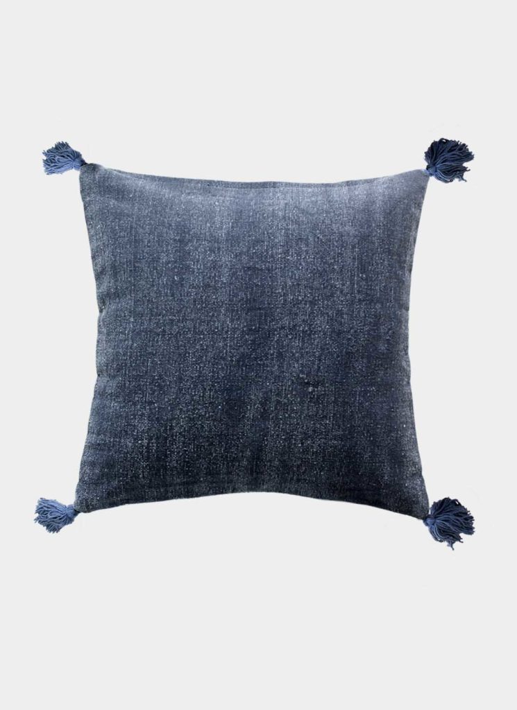 The RAMSHA HOME Polyester Geometry Cushion With Tassel cs-236 is a square, dark blue velvet cushion with corner tassels and a subtle texture, shown against a light grey background.