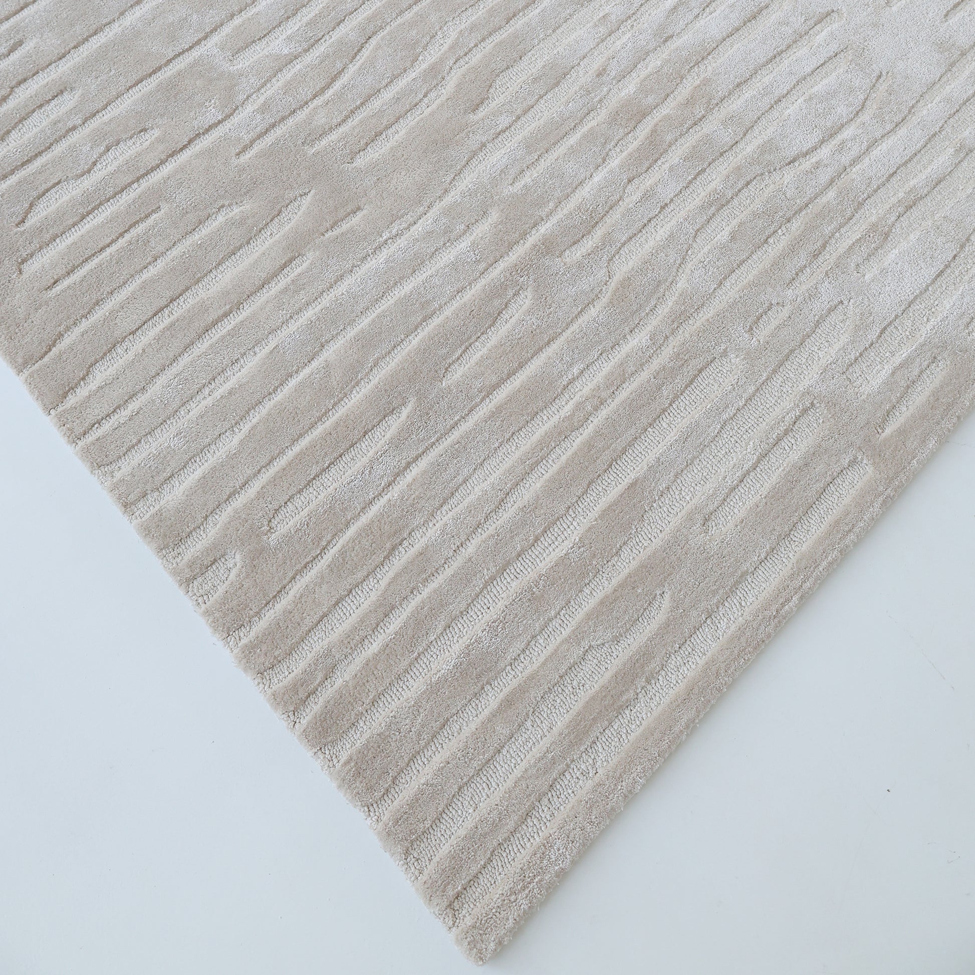 The RAMSHA HOME "Home Decor Handmade Area Rug - HTV 17" is a beige, hand-tufted rug with a subtle raised diagonal pattern, shown close-up and angled on a light background.