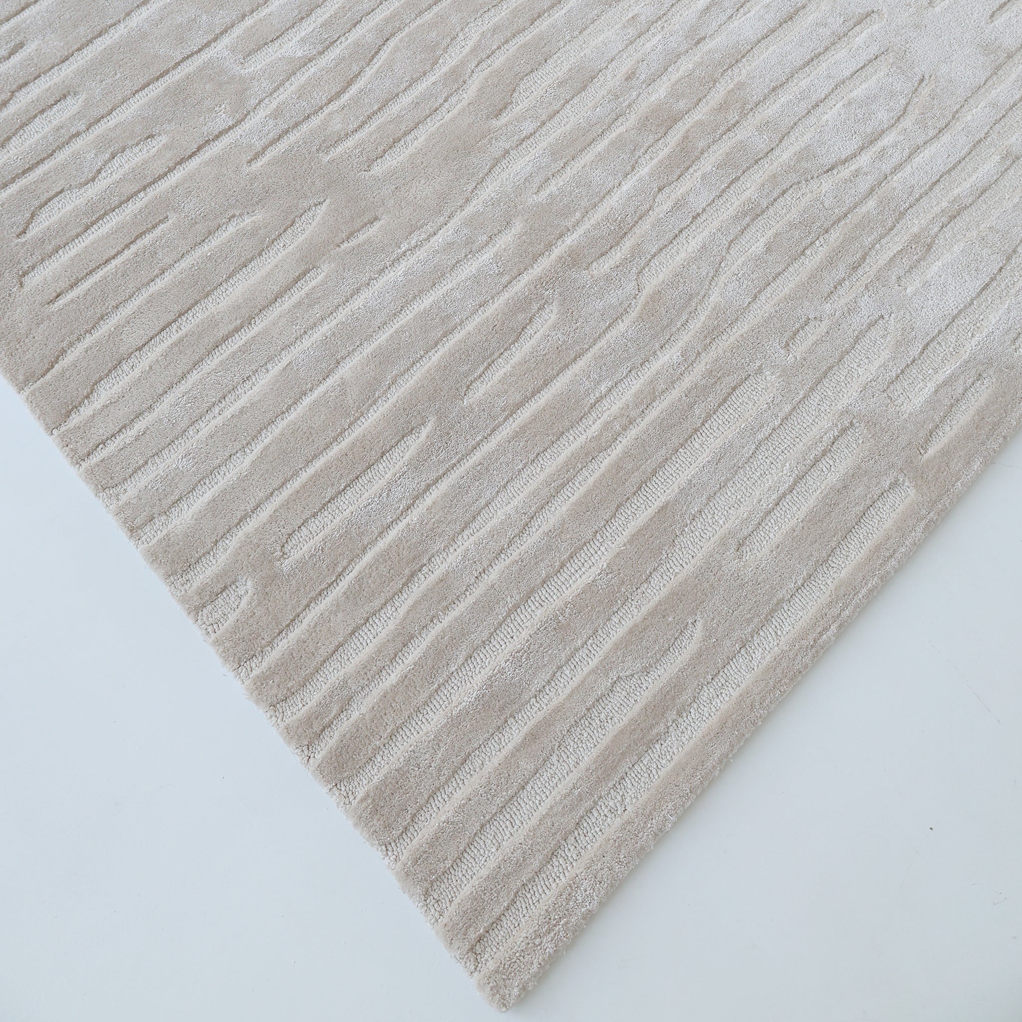 The RAMSHA HOME "Home Decor Handmade Area Rug - HTV 17" is a beige, hand-tufted rug with a subtle raised diagonal pattern, shown close-up and angled on a light background.