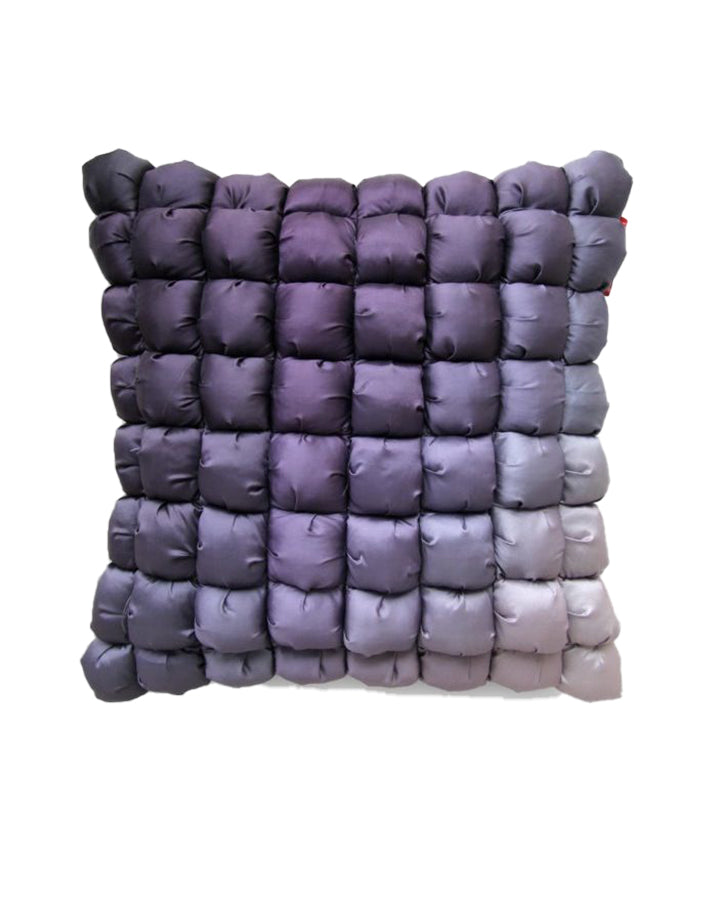 The RAMSHA HOME Polyester Bubble Cushion Cover features small, puffy fabric squares in a grid pattern with a gradient design from dark purple at the top left to light gray at the bottom right.