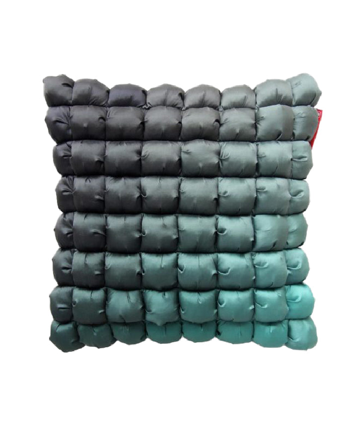 The RAMSHA HOME Polyester Bubble Cushion Cover is a rectangular pillow with a quilted, grid pattern and gradient dark gray-to-teal color, featuring a fitted polyester cover. Isolated on a white background.
