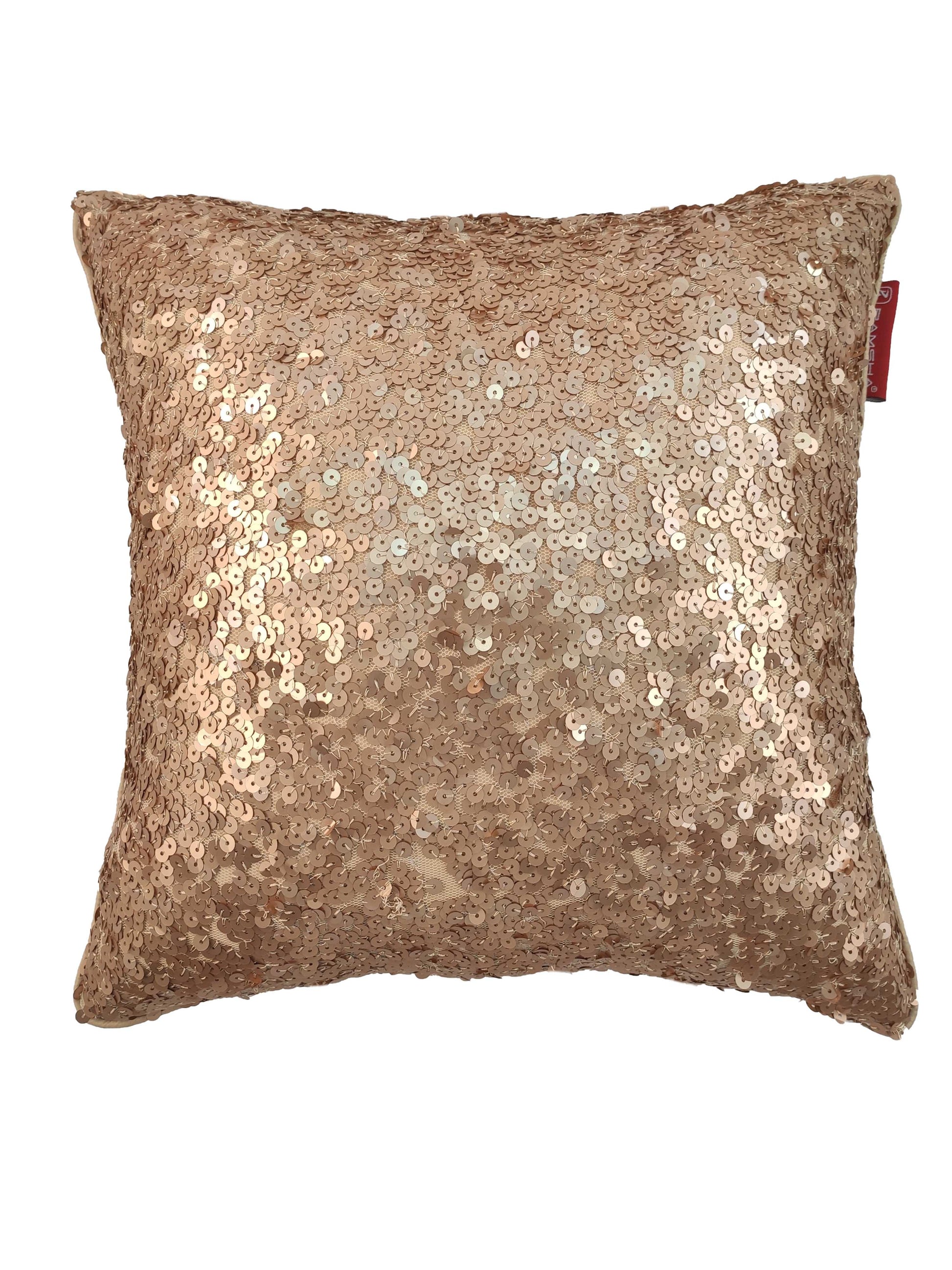 The RAMSHA HOME Polyester Sequine Cushion Cover features shiny gold sequins and a textured, reflective surface. A small red tag adds detail, making it a bold accent for your living room. Displayed against a white background.