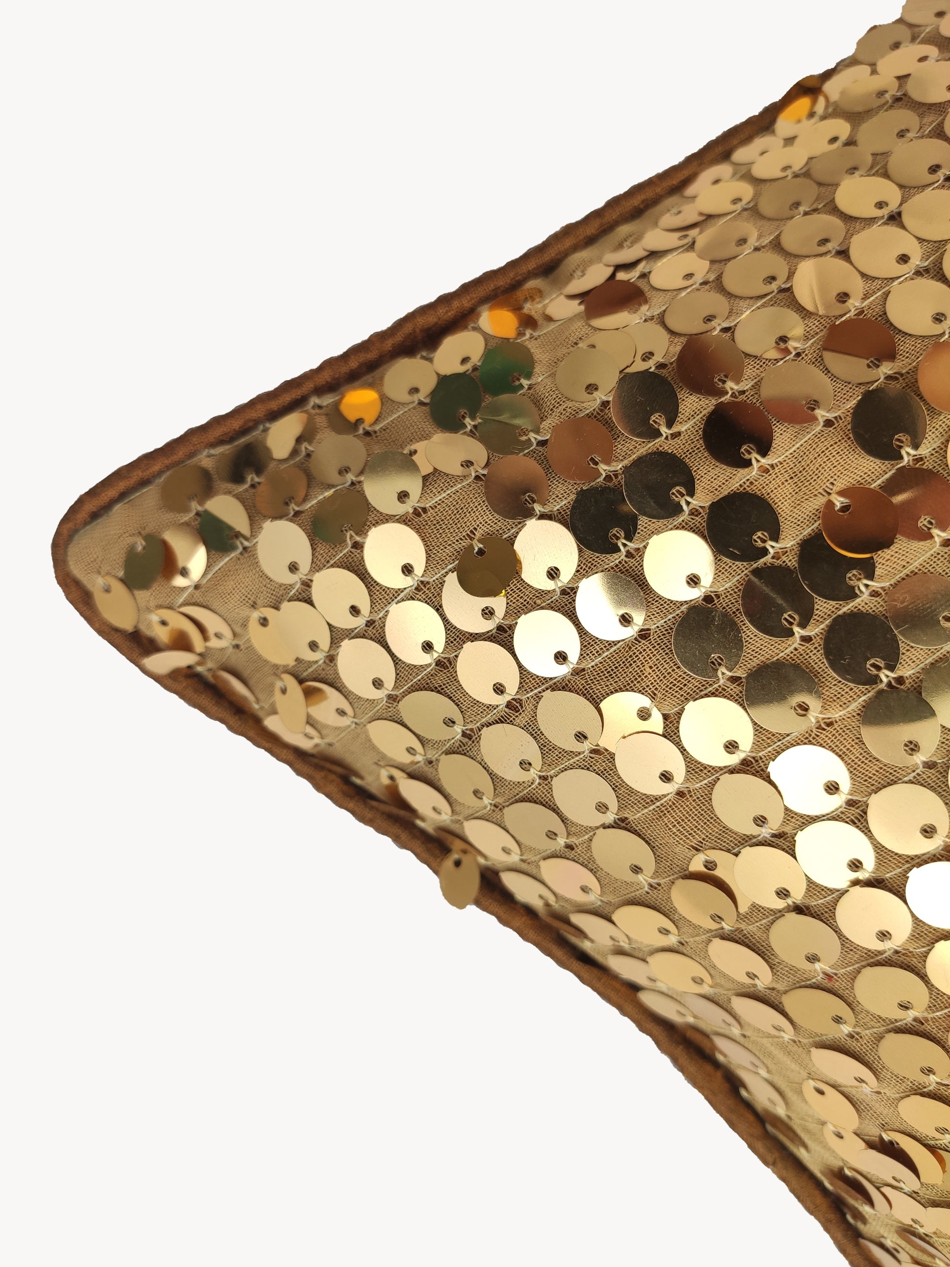 Close-up of RAMSHA HOME's Polyester Sequine Cushion Cover, featuring shiny gold sequins on a tan background—an ideal accent to add sparkle and style to your living room.