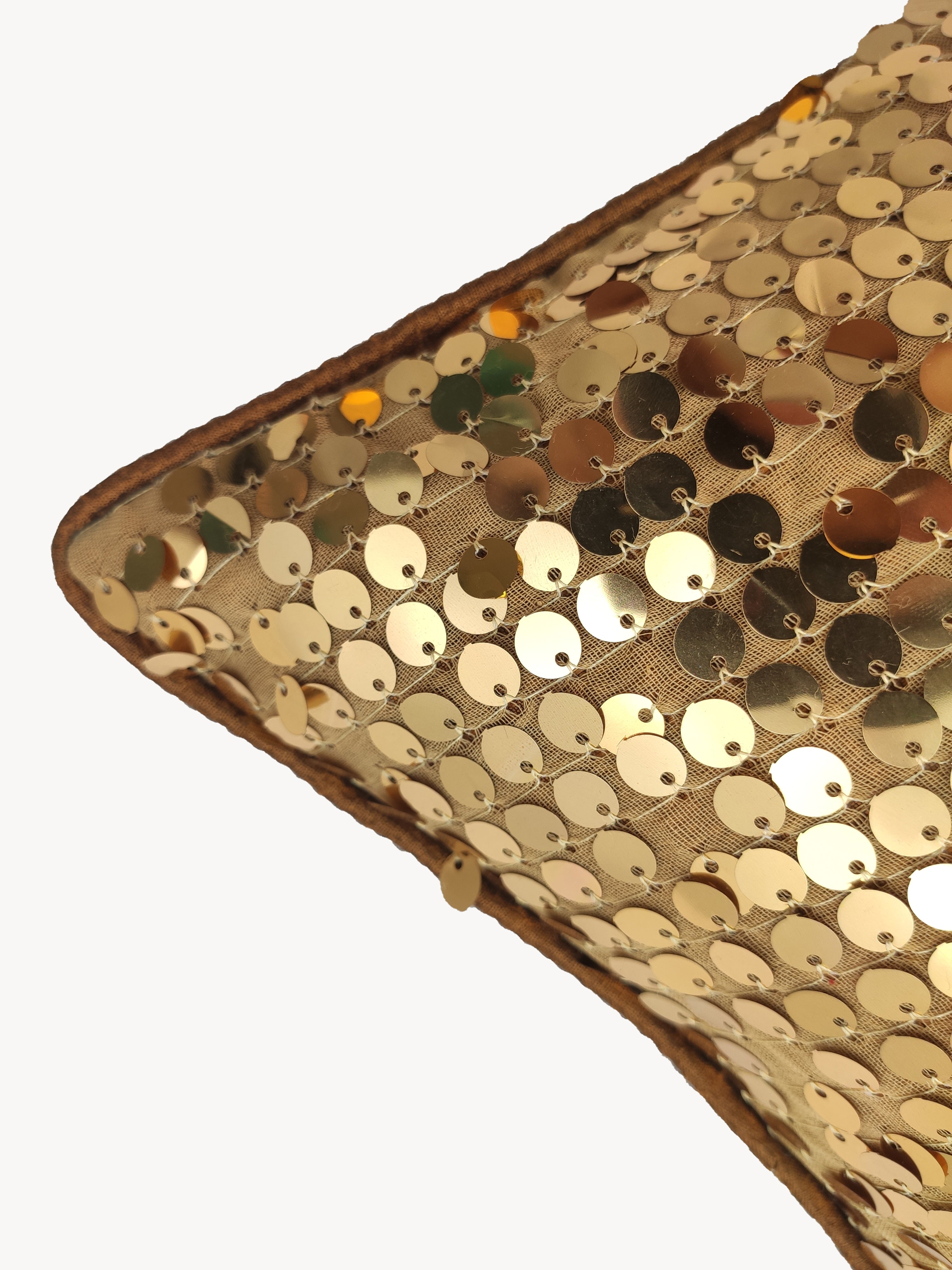 Close-up of RAMSHA HOME's Polyester Sequine Cushion Cover, featuring shiny gold sequins on a tan background—an ideal accent to add sparkle and style to your living room.
