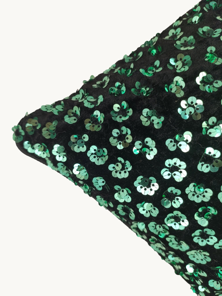 The RAMSHA HOME Decorative Polyester Cushion Cover features a black corner embellished with shiny green sequin flower patterns, displayed against a plain white background.
