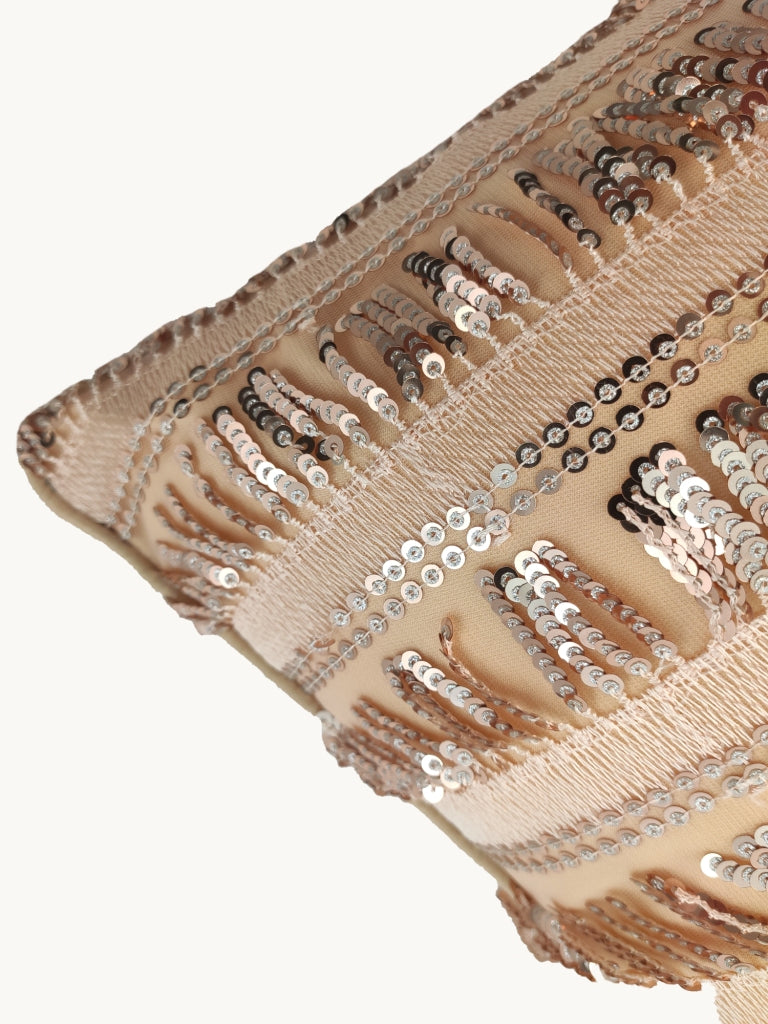 Close-up of the RAMSHA HOME Modern Polyester Cushion Cover in beige, highlighted by shiny silver sequins and textured fringes in wavy horizontal patterns.