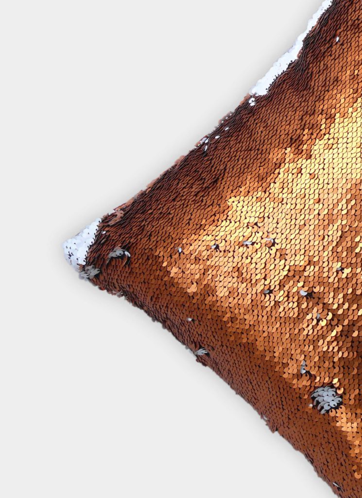 A close-up of the RAMSHA HOME Cushion Cover in copper and white sequins on a light background. This Home Decor piece adds shine and textured elegance with a subtle gradient—ideal for any living room.
