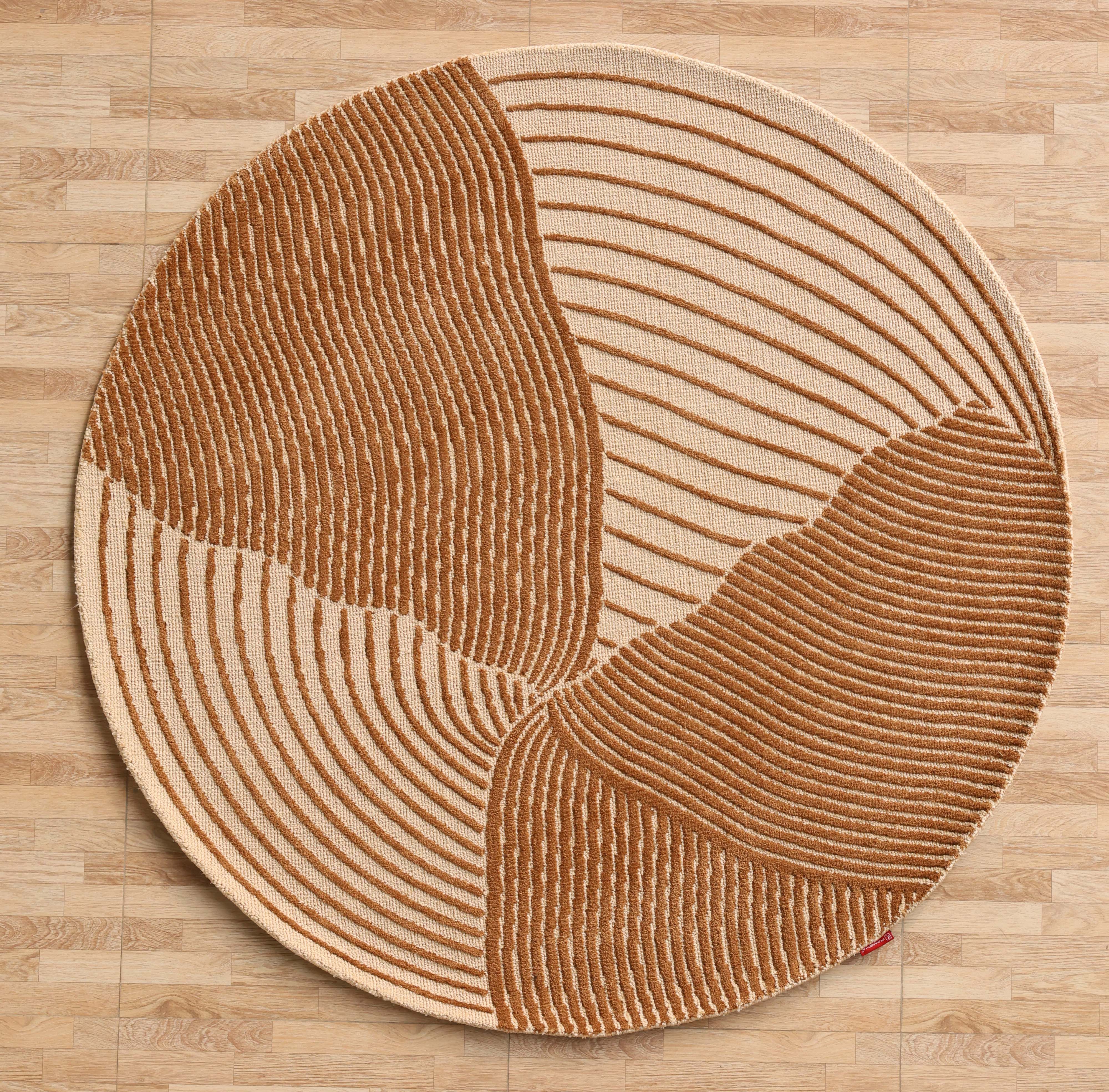 The Layered Wave Modern Round Abstract Rug CMN 106 by RAMSHA HOME features beige and brown wavy stripes in four curved sections, adding a stylish, contemporary touch to spaces with its modern design and textured patterns.