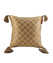 The RAMSHA HOME Gold Color Cushion Cover With Tassel CS-045 features a stylized leaf design, subtle sheen, golden beige tassels, and a small red tag—perfect for stylish home decor.