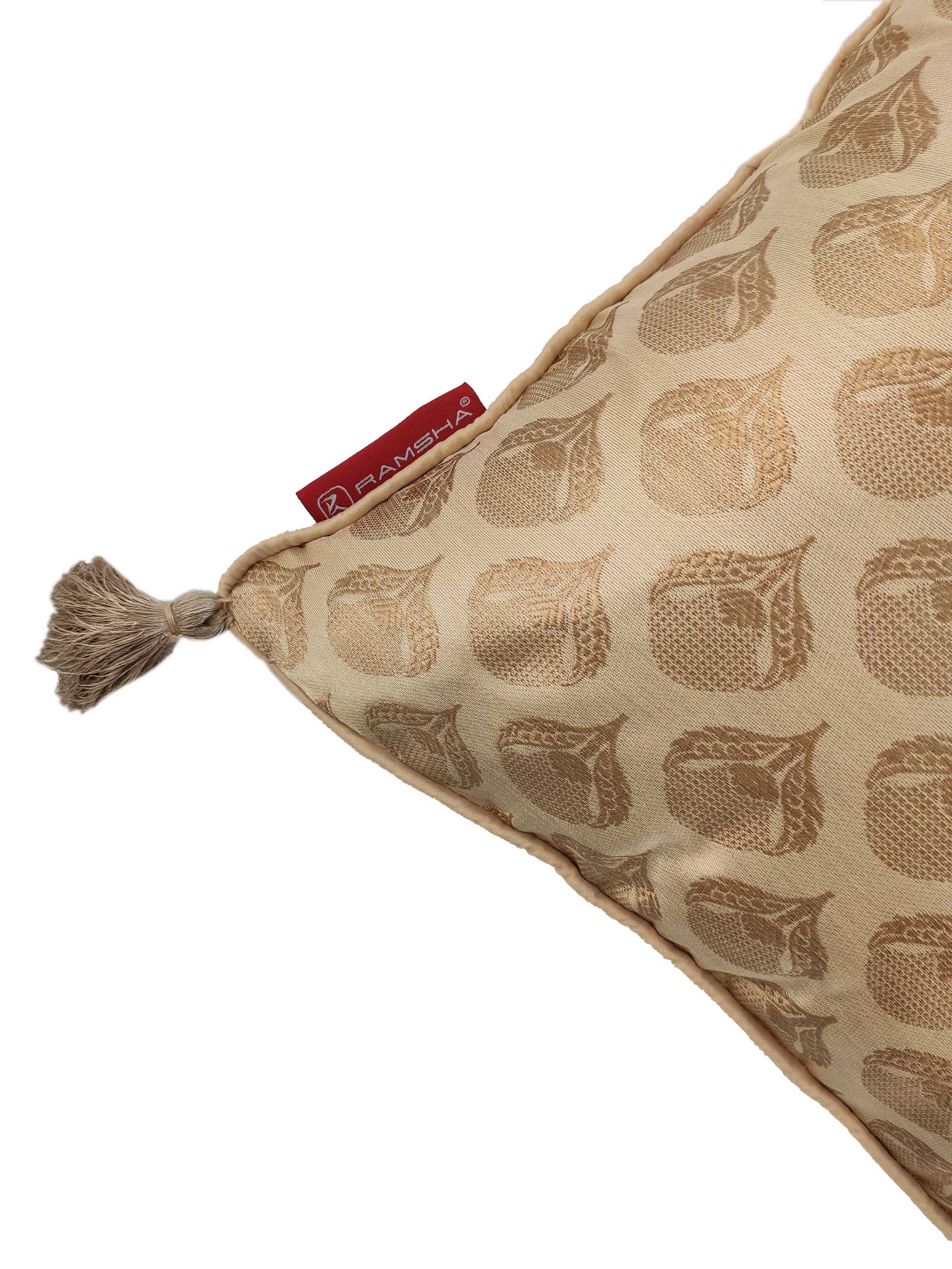 The Gold Color Cushion Cover With Tassel CS-045 by RAMSHA HOME features a chic tassel on one corner and a red “RAMSHA” tag—an elegant choice for adding stylish charm to your home décor.