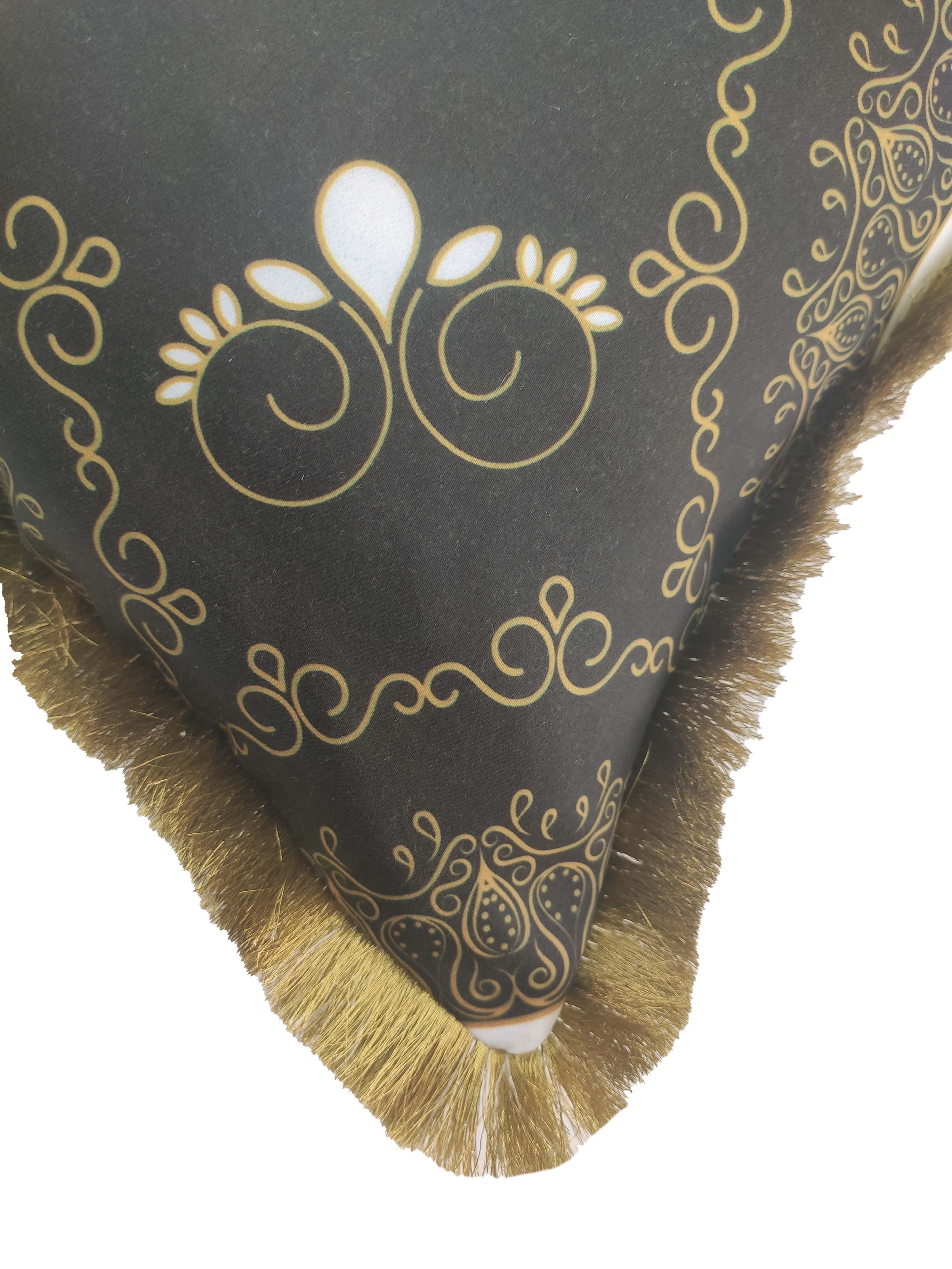 A close-up of RAMSHA HOME's Printed Polyester Cushion With Filler CS-053, showcasing black fabric, gold ornate patterns, and golden fringe trim along the edge.