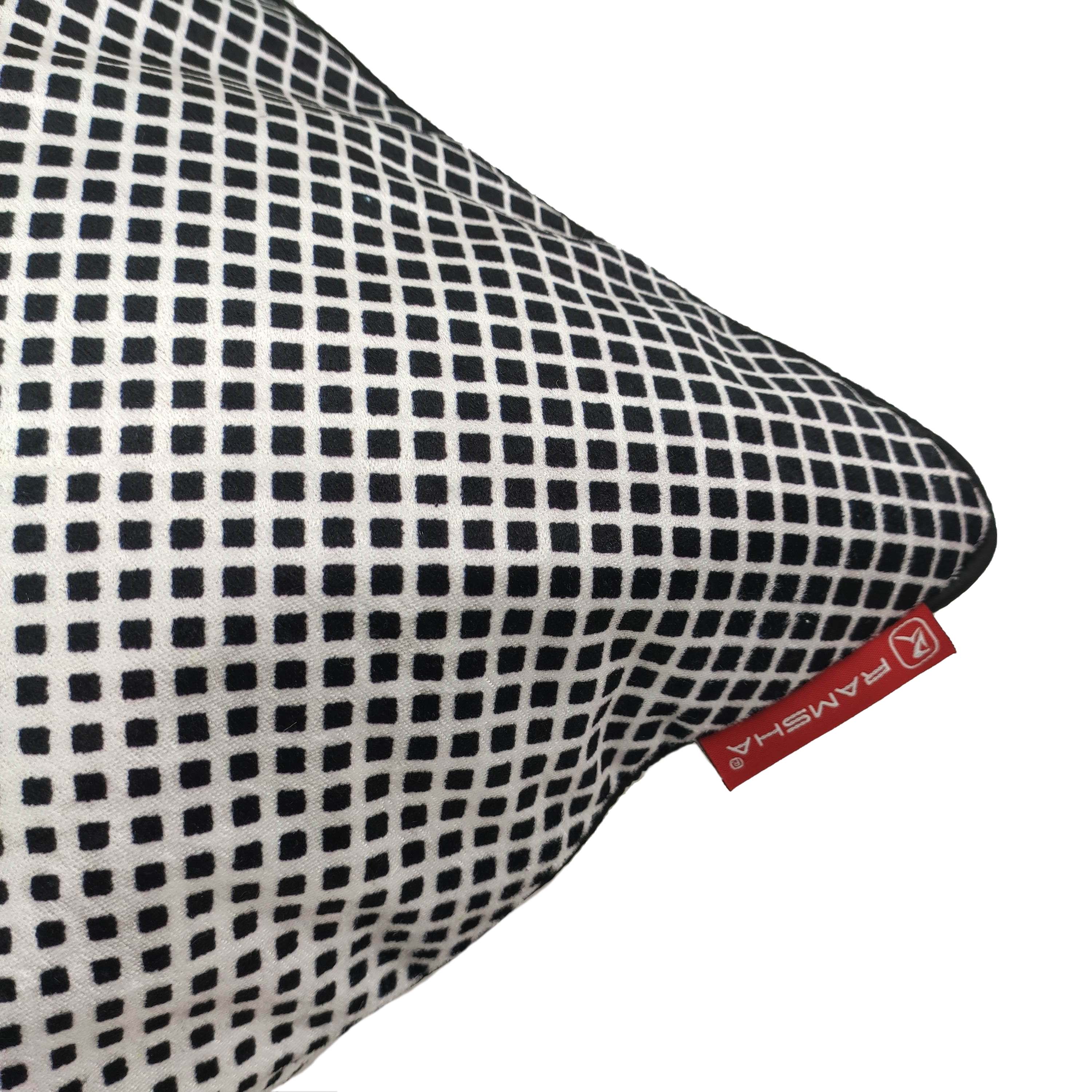 A close-up of the RAMSHA HOME Cushion Cover Black & White Color CS-074, featuring a black-and-white checkered pattern and a red fabric tag with the brand name—an ideal accent for modern home décor.