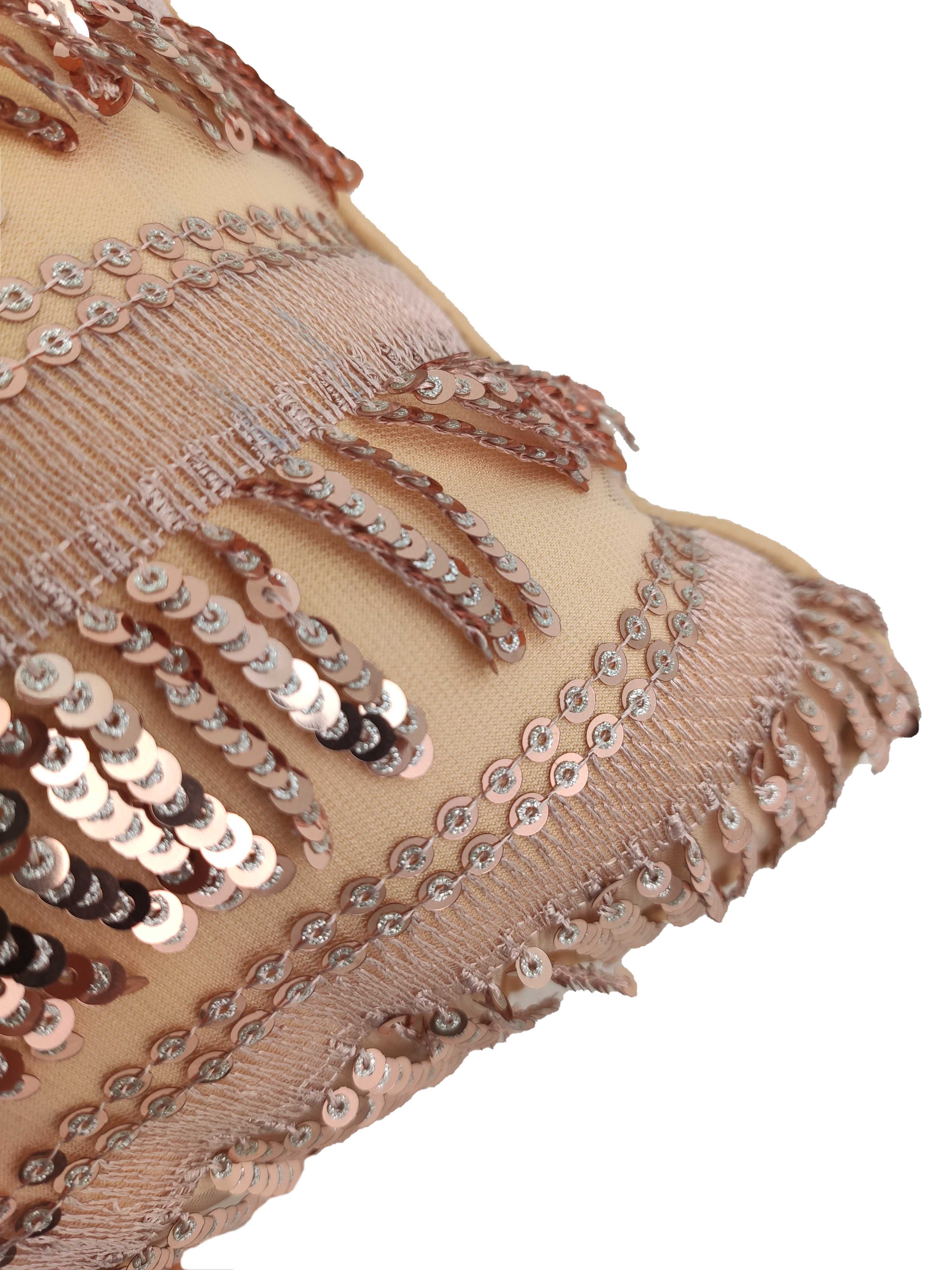 The RAMSHA HOME Polyester Sequence Cushion With Filler features durable light peach polyester adorned with shiny sequins and matching fringe, offering a textured, shimmering look and comfortable support.