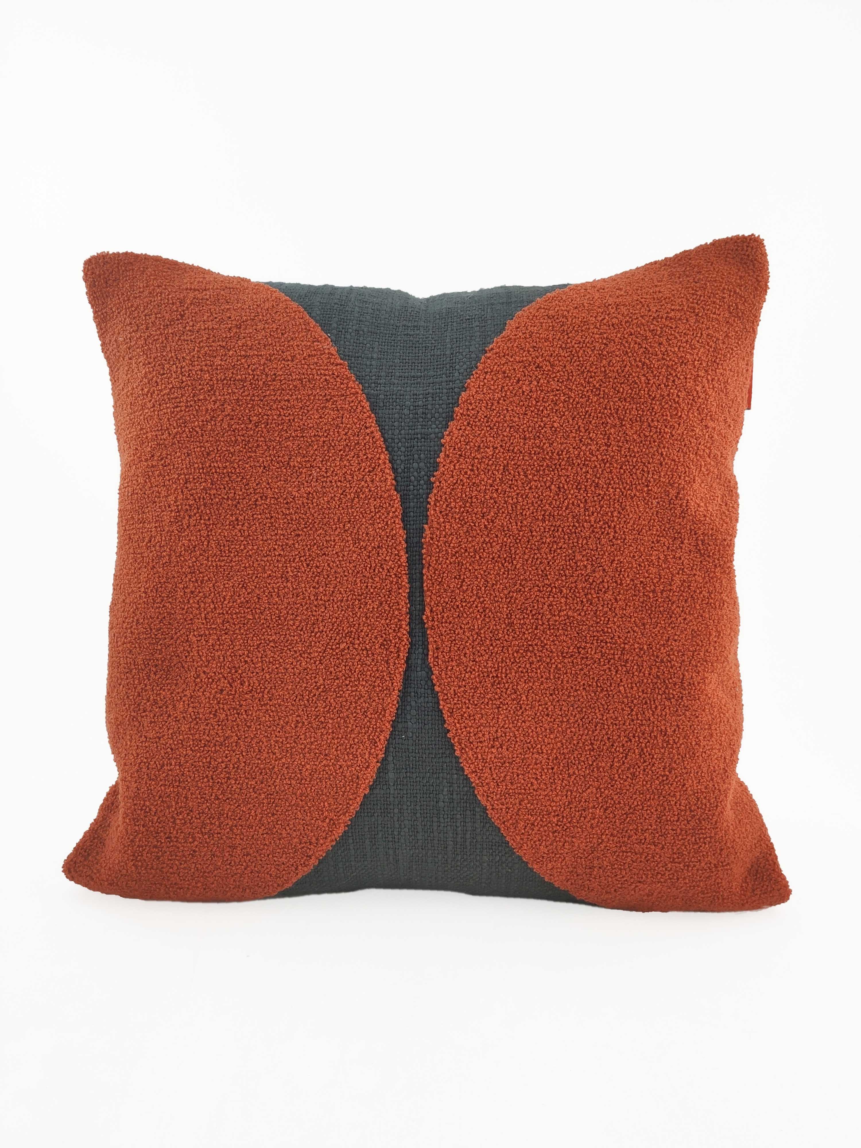 The RAMSHA HOME Rust Color Cushion CS-121 features a square design with a dark cotton-polyester base and two textured rust-orange semi-circles on the front, offering an abstract modern look ideal for stylish home décor.