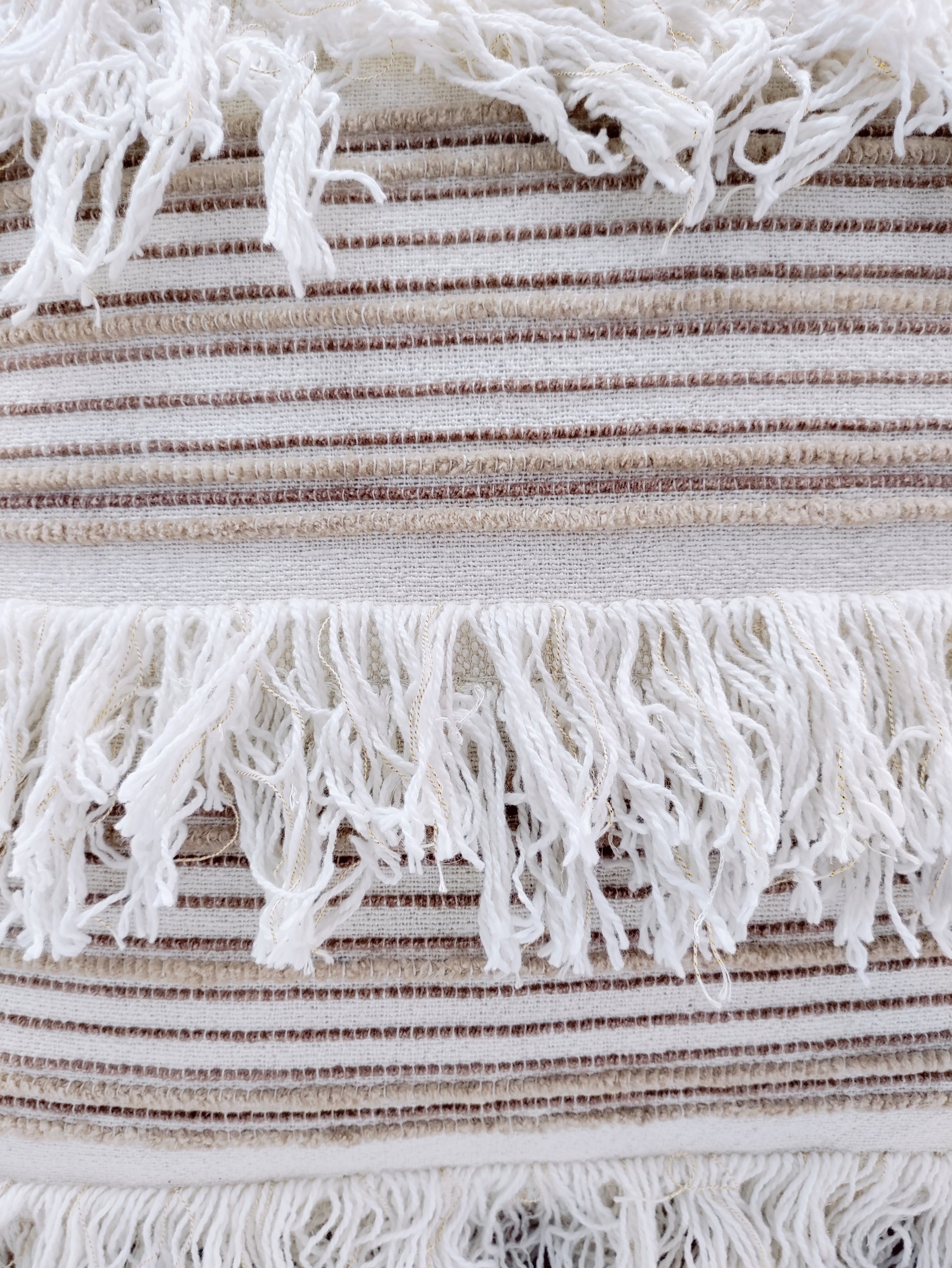 Close-up of RAMSHA HOME's Woven Cotton Cushion With Tassel cs-152, featuring textured brown and white horizontal stripes and rows of long white fringes. This soft cotton cushion can also be used as a stylish cover for a cushion insert.