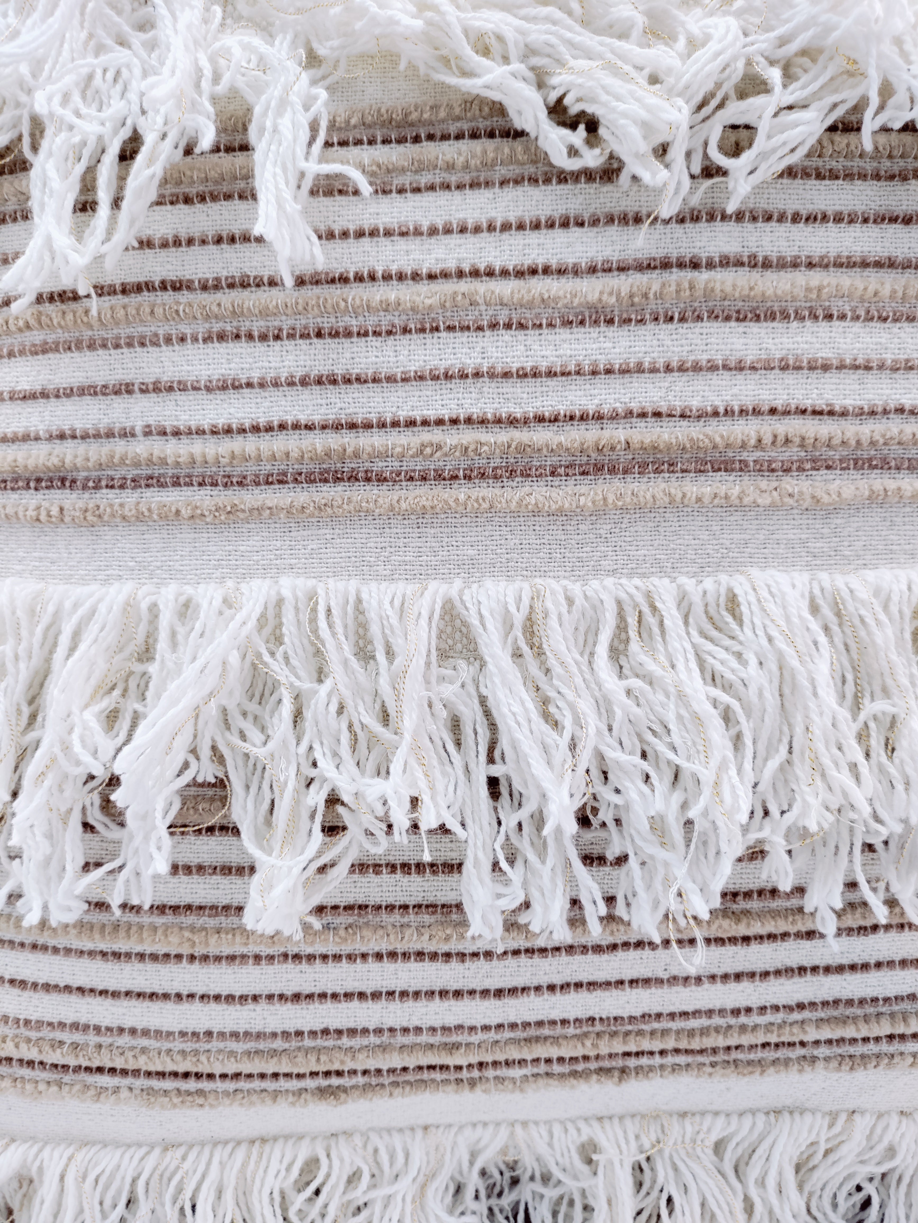 Close-up of RAMSHA HOME's Woven Cotton Cushion With Tassel cs-152, featuring textured brown and white horizontal stripes and rows of long white fringes. This soft cotton cushion can also be used as a stylish cover for a cushion insert.