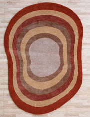 The RAMSHA HOME Soft Plush Abstract Shape Shaggy Rug – Terracotta Beige (SG 045) features a unique design with concentric rings in brown, tan, and red, displayed on a light wood floor.