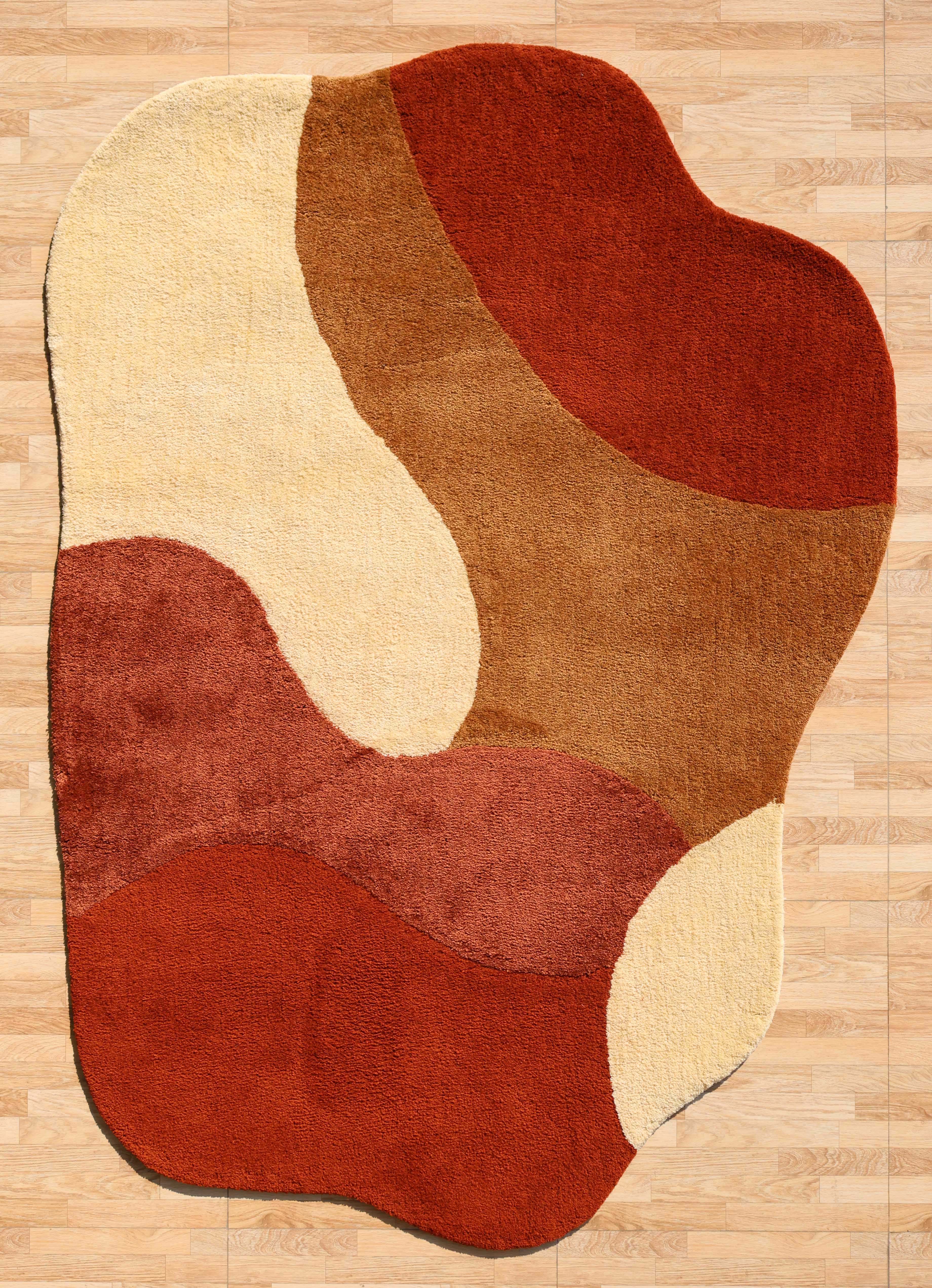 The RAMSHA HOME Terracotta Beige Soft Irregular Shape Shaggy Rug (SG 046) features plush, wavy layers in red, brown, and beige tones, adding a cozy, organic touch to light wood floors with its unique curved pattern.