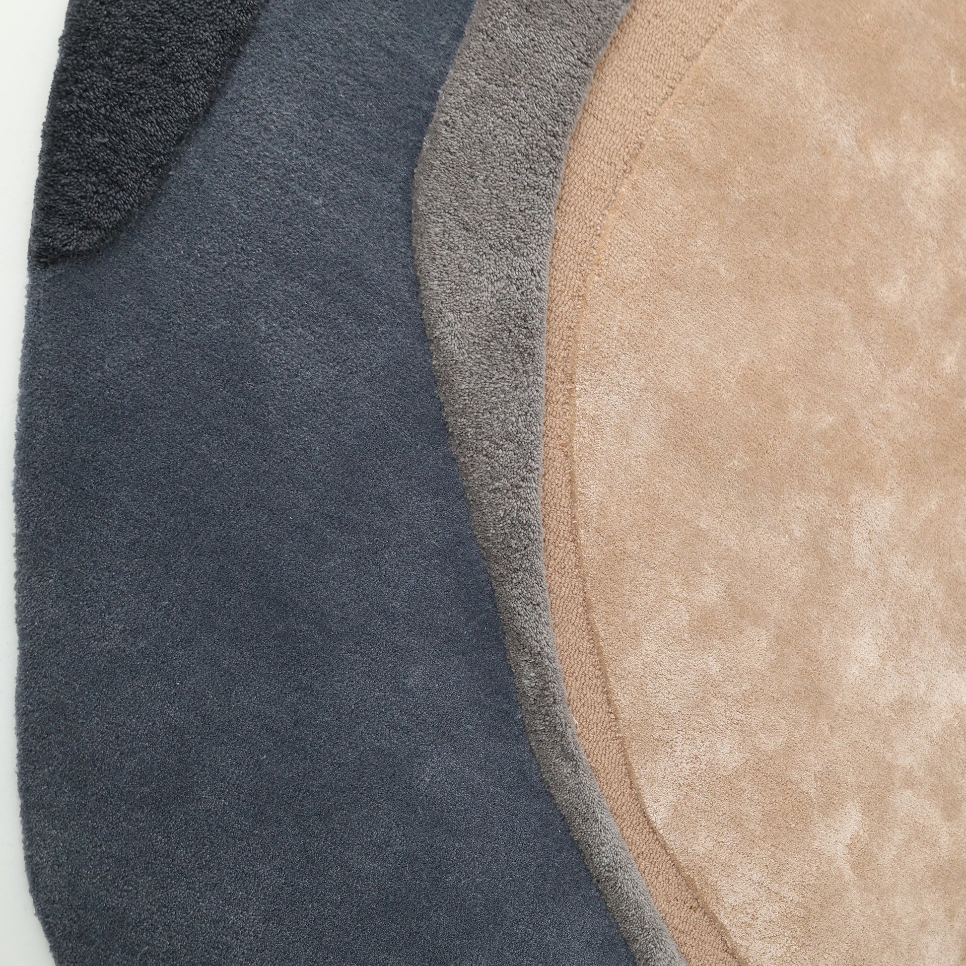 The RAMSHA HOME Oval Shape Home Decor Multi Color Rug HTWV-90 features three overlapping, irregular oval rugs in dark blue, gray, and light beige, each with a soft, plush wool texture for comfort and modern style.