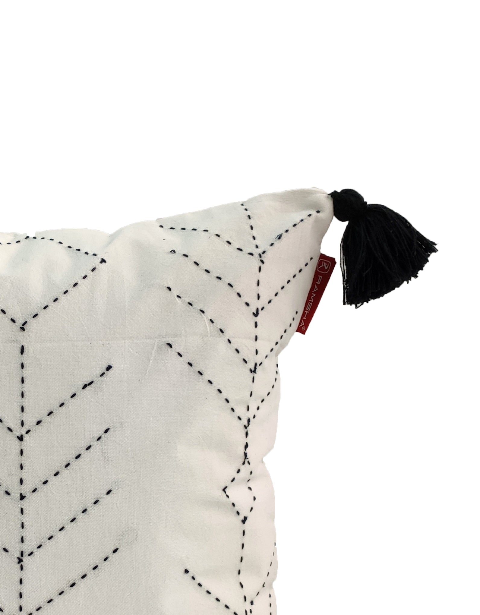 The RAMSHA HOME Embroidery White And Black Cotton Cushion With Tassel CS-191 features stylish black stitched chevrons, a top black tassel, and a small red fabric tag. Only part of this chic cushion is visible.