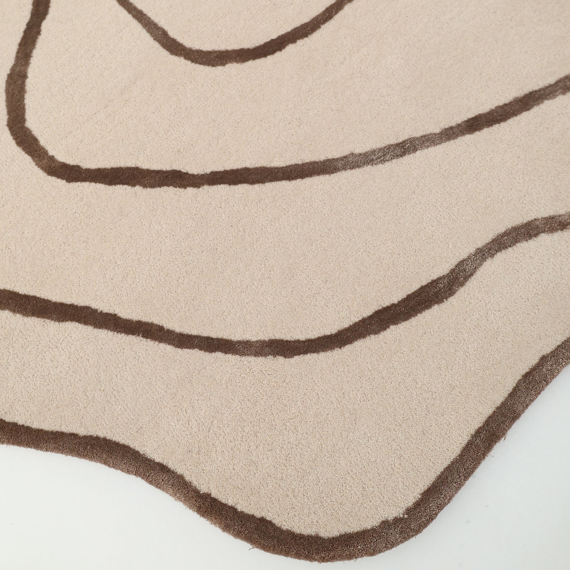 The RAMSHA HOME Handmade Multi Color Hand-Tufted Area Rug HTWV-65 features cream tones with wavy brown lines reminiscent of contour maps and an organic, uneven edge for a distinctive, artistic look.