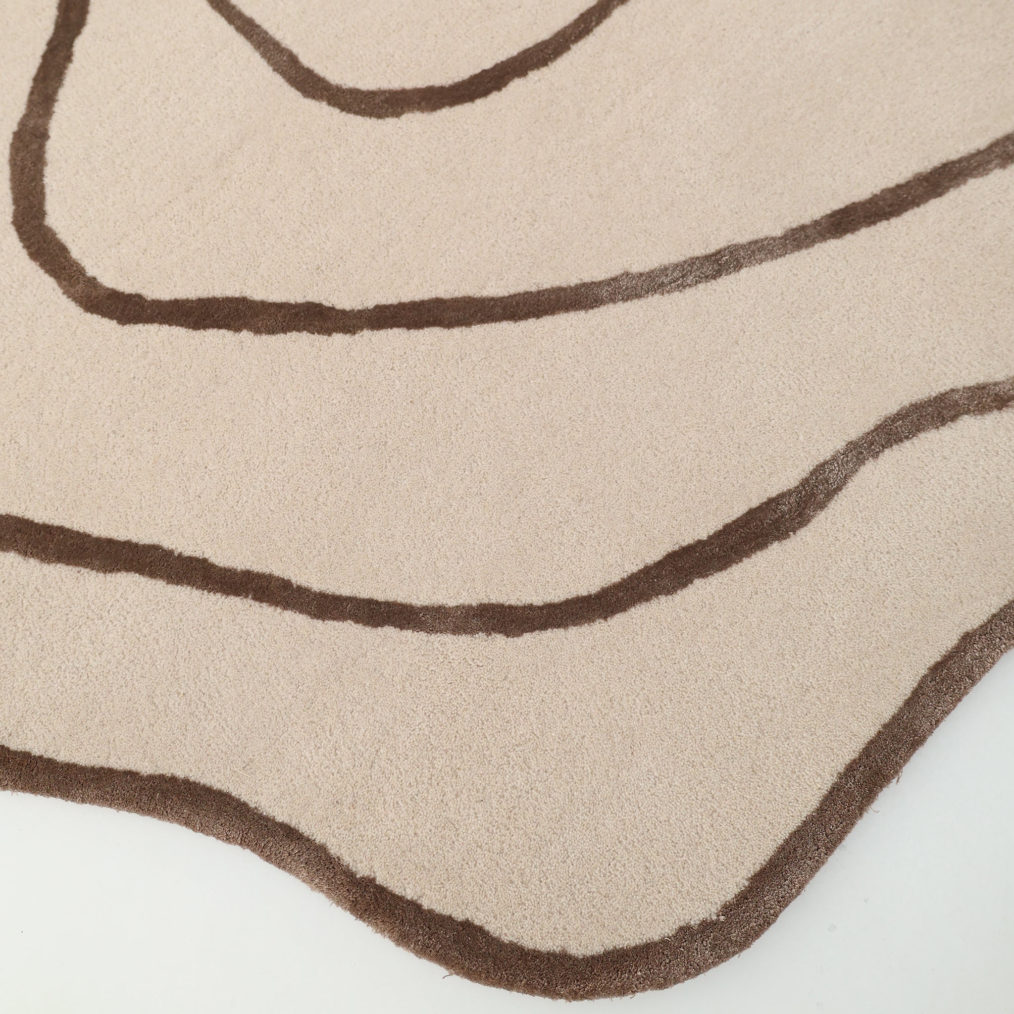 The RAMSHA HOME Handmade Multi Color Hand-Tufted Area Rug HTWV-65 features cream tones with wavy brown lines reminiscent of contour maps and an organic, uneven edge for a distinctive, artistic look.