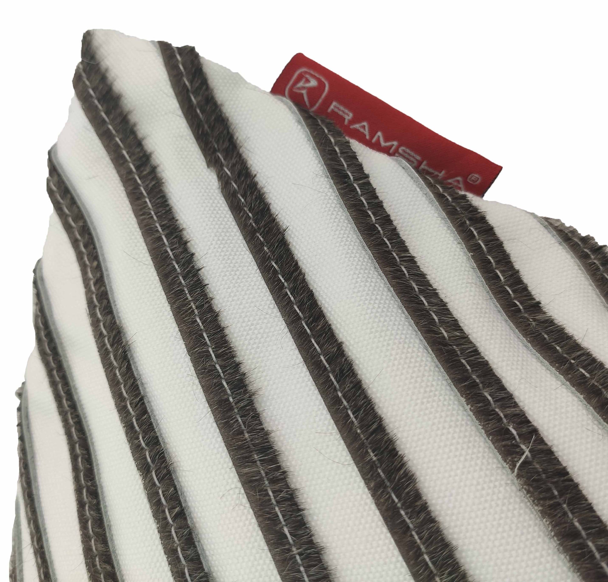 Close-up of the Leather And Polyester Cushion CS-109 with diagonal brown stripes and visible stitching, featuring a red fabric tag with the RAMSHA HOME brand name partially visible at the top.