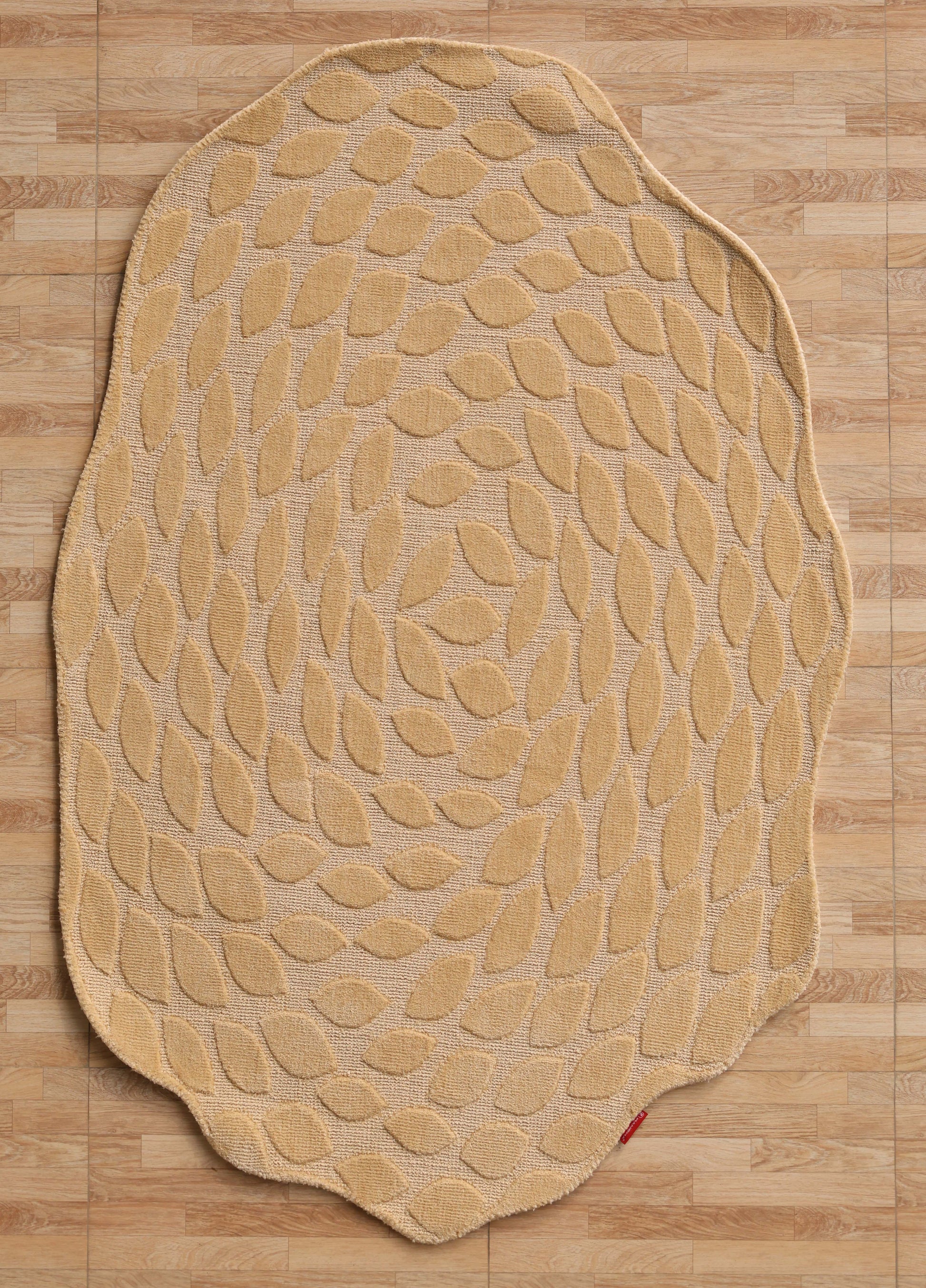 The RAMSHA HOME Autumn Leaf Organic Shaped Rug Beige CMN 103 features an uneven edge and repeating leaf pattern, shown here on a parquet wooden floor.