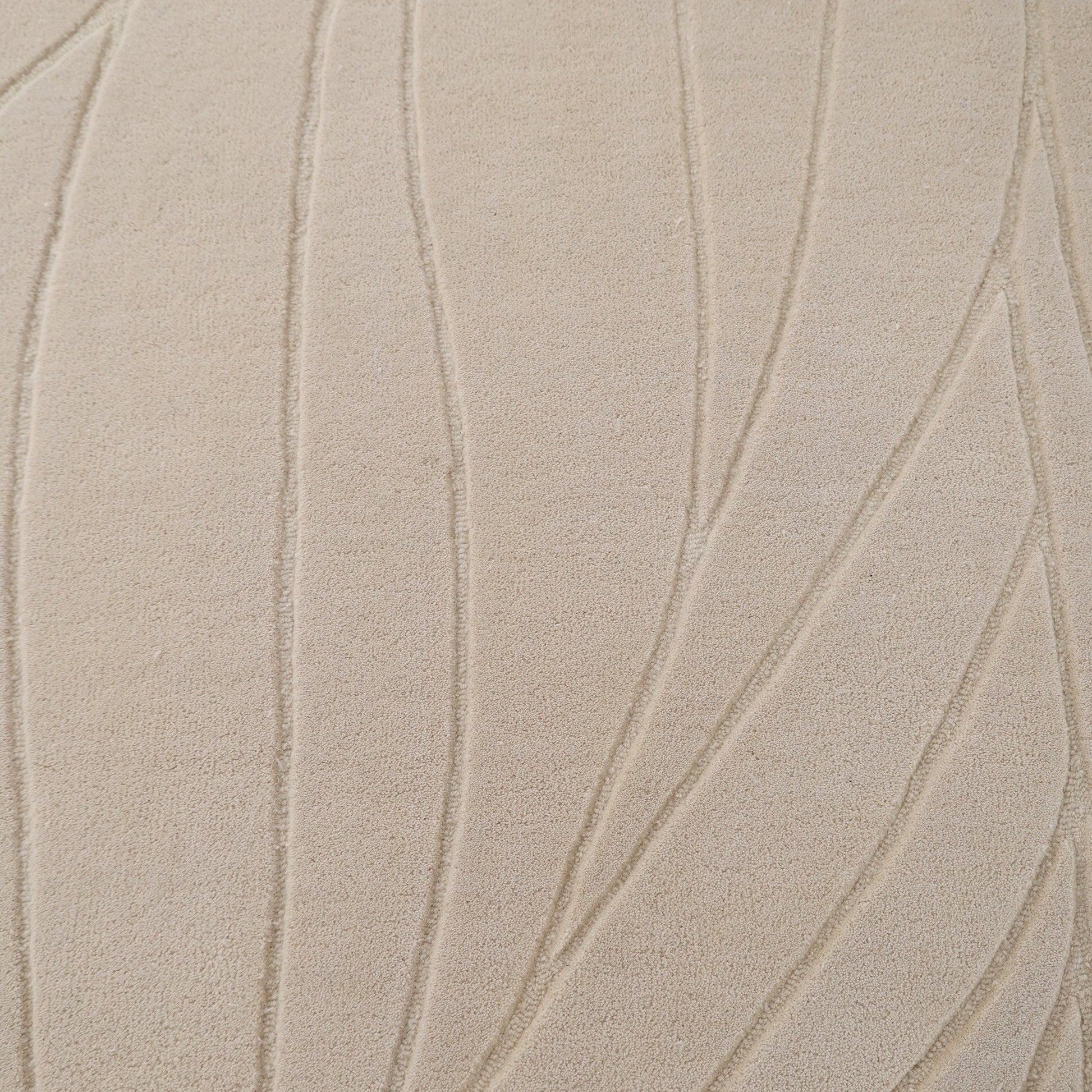 Close-up of the RAMSHA HOME Beige Color Handmade Rug - HTW 105 (300x400 cm), featuring a soft, neutral wool surface with a carved texture and raised abstract leaf motifs in curved and straight embossed lines for an organic look.
