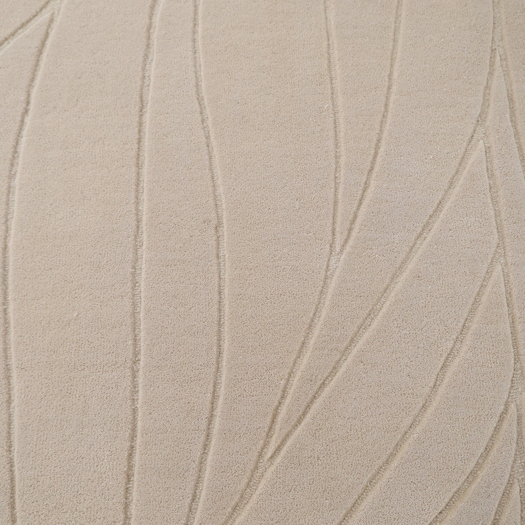 Close-up of the RAMSHA HOME Beige Color Handmade Rug - HTW 105 (300x400 cm), featuring a soft, neutral wool surface with a carved texture and raised abstract leaf motifs in curved and straight embossed lines for an organic look.