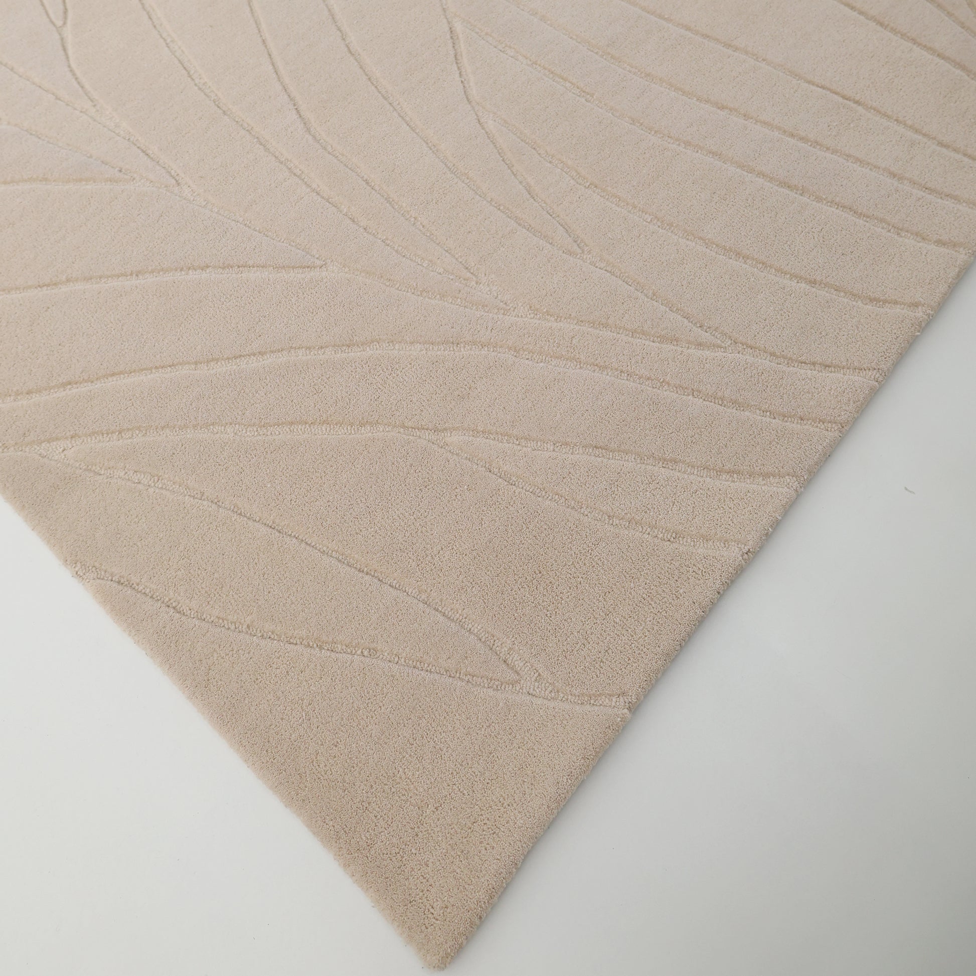 A close-up of the RAMSHA HOME Beige Color Handmade Rug - HTW 105 (300x400 cm), featuring a textured, abstract line pattern and carved details, displayed on a white background.
