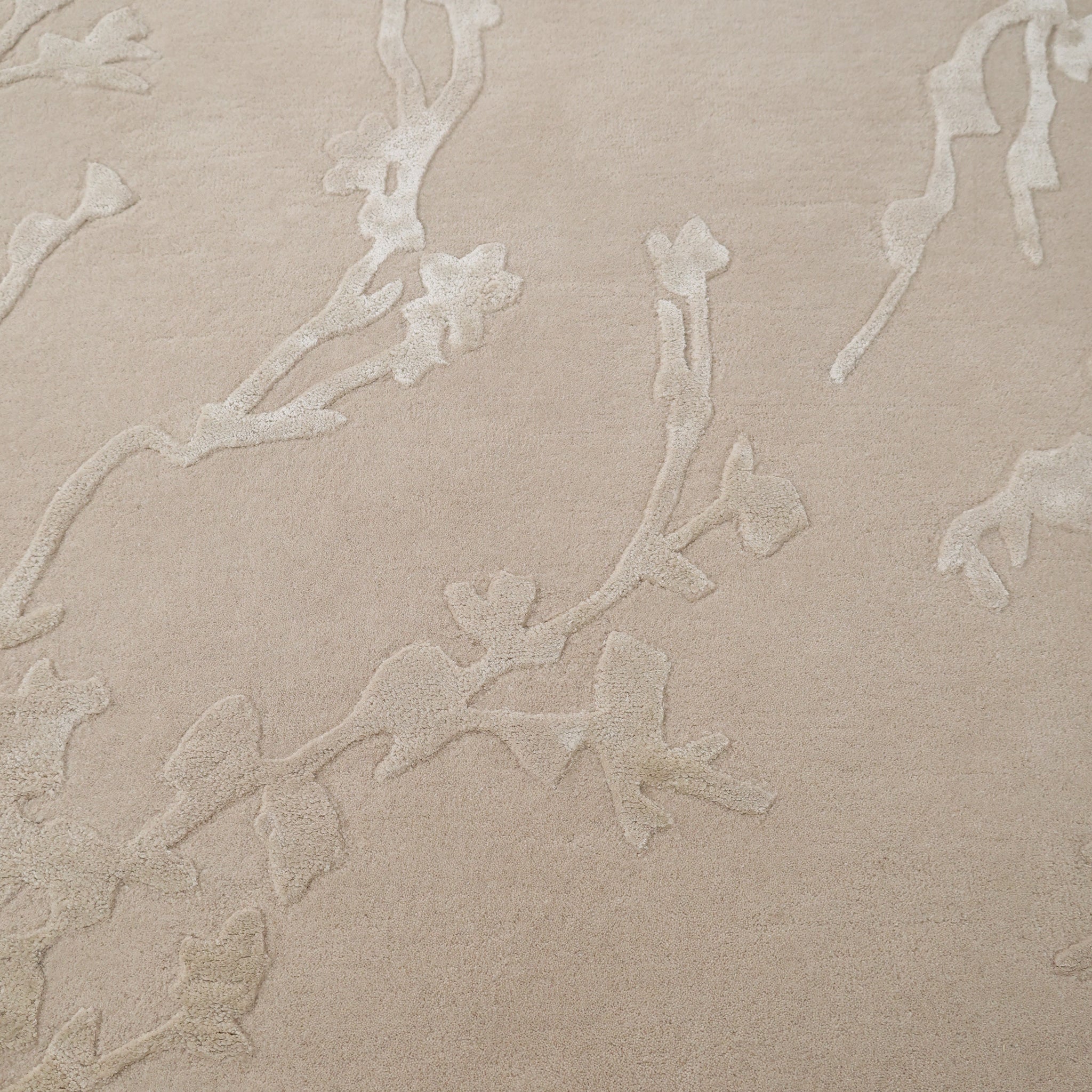 The RAMSHA HOME Decorative Handmade Area rug HTWV-118 features a beige floral textured design with a subtle raised branch pattern, adding warmth and elegance to your bedroom as a neutral accent piece.