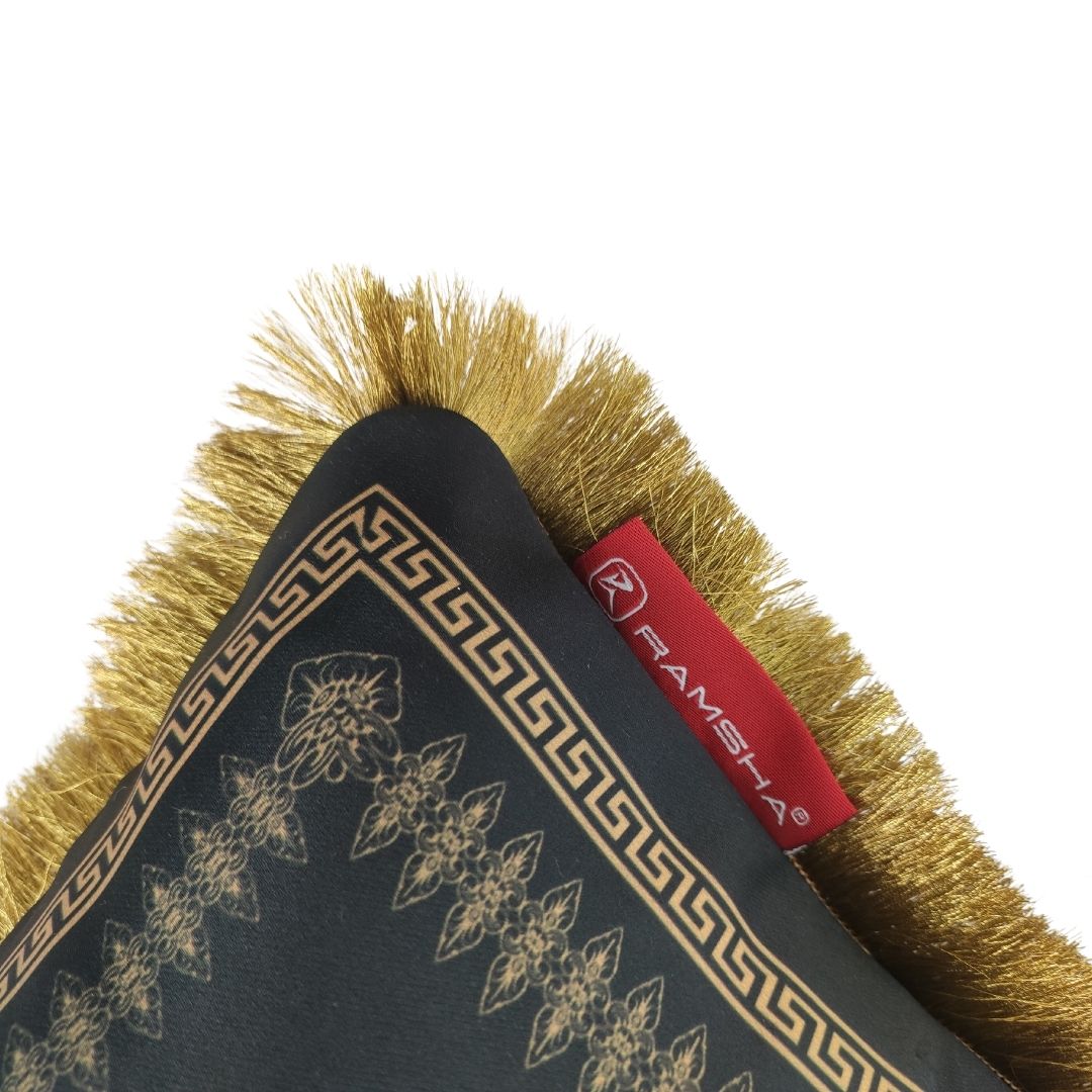 Close-up of Cushion With Filler For Bedroom CS-065 by RAMSHA HOME: black cushion with gold embroidery, gold fringed edge, and red RAMSHA HOME tag. Made from soft touch fabric with intricate floral and geometric patterns.