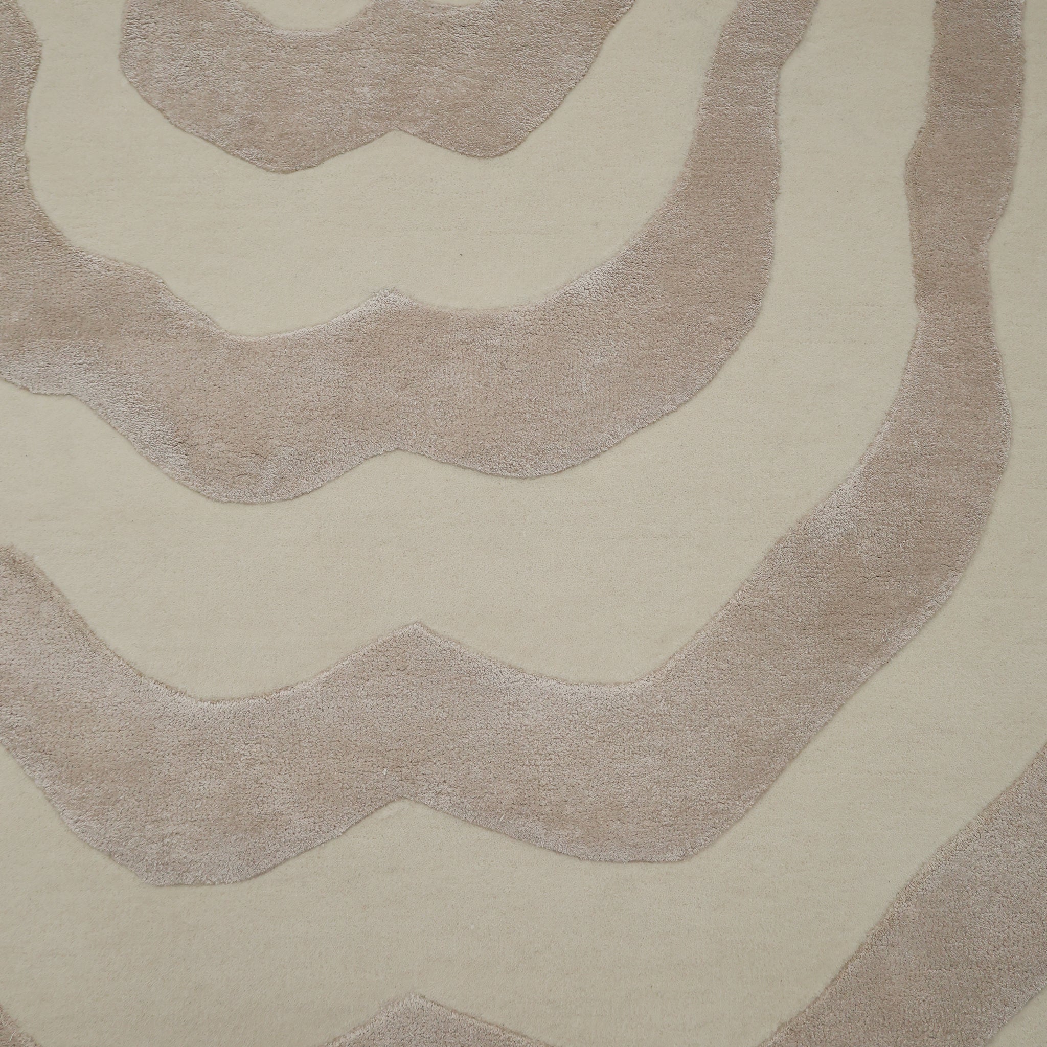 The RAMSHA HOME Beige & Cream Wavy Handmade Area Rug (HTWV-144) features an organic abstract pattern with irregular tan stripes across its neutral beige surface.