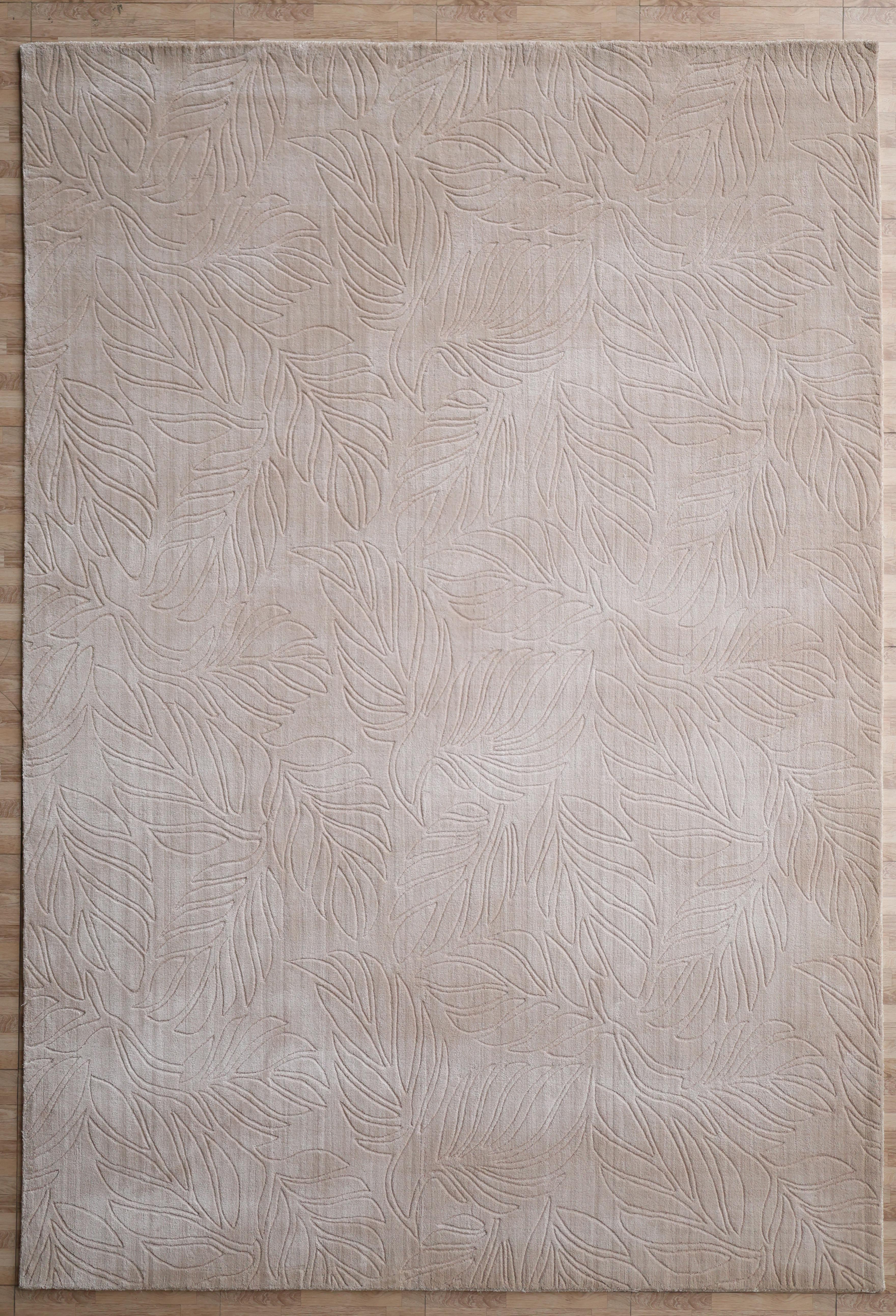 The RAMSHA HOME Nature Leaf Handmade Contemporary Rug 250x350 cm (LKH-048) features a neutral ivory tone and embossed overlapping leaf pattern, adding textured elegance to light wood floors.