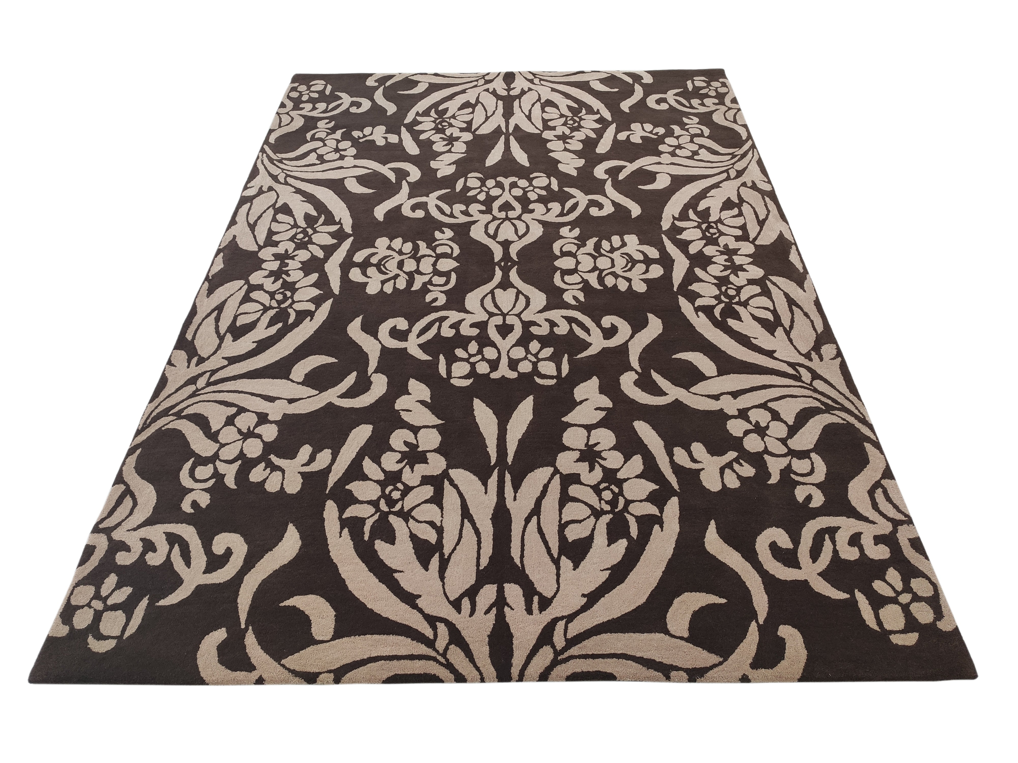 The RAMSHA HOME Home Decor Dark Shade Handmade Carpet – HTW-31 is a rectangular hand-tufted rug with a dark brown base and an intricate, symmetrical beige floral and leaf pattern covering the surface.