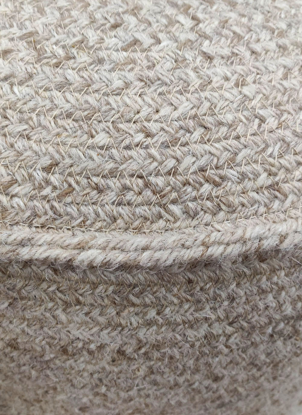 Close-up of the textured beige fabric on the RAMSHA HOME Natural Wool Pouf With Leather Handle PF-052, featuring interlaced fibers and a visible horizontal seam for a rustic, natural look—ideal for your living space.